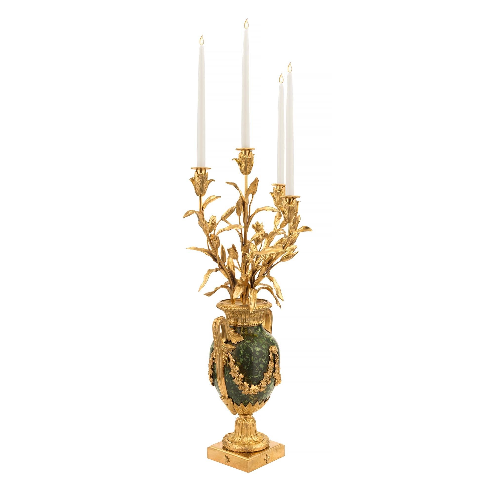 A sensational and extremely high quality pair of French 19th century Louis XVI st. ormolu and green Porphyry, four arm candelabras. Each large scale candelabra is raised by a square ormolu base with an elegant central Fleur de Lys and delicate stars