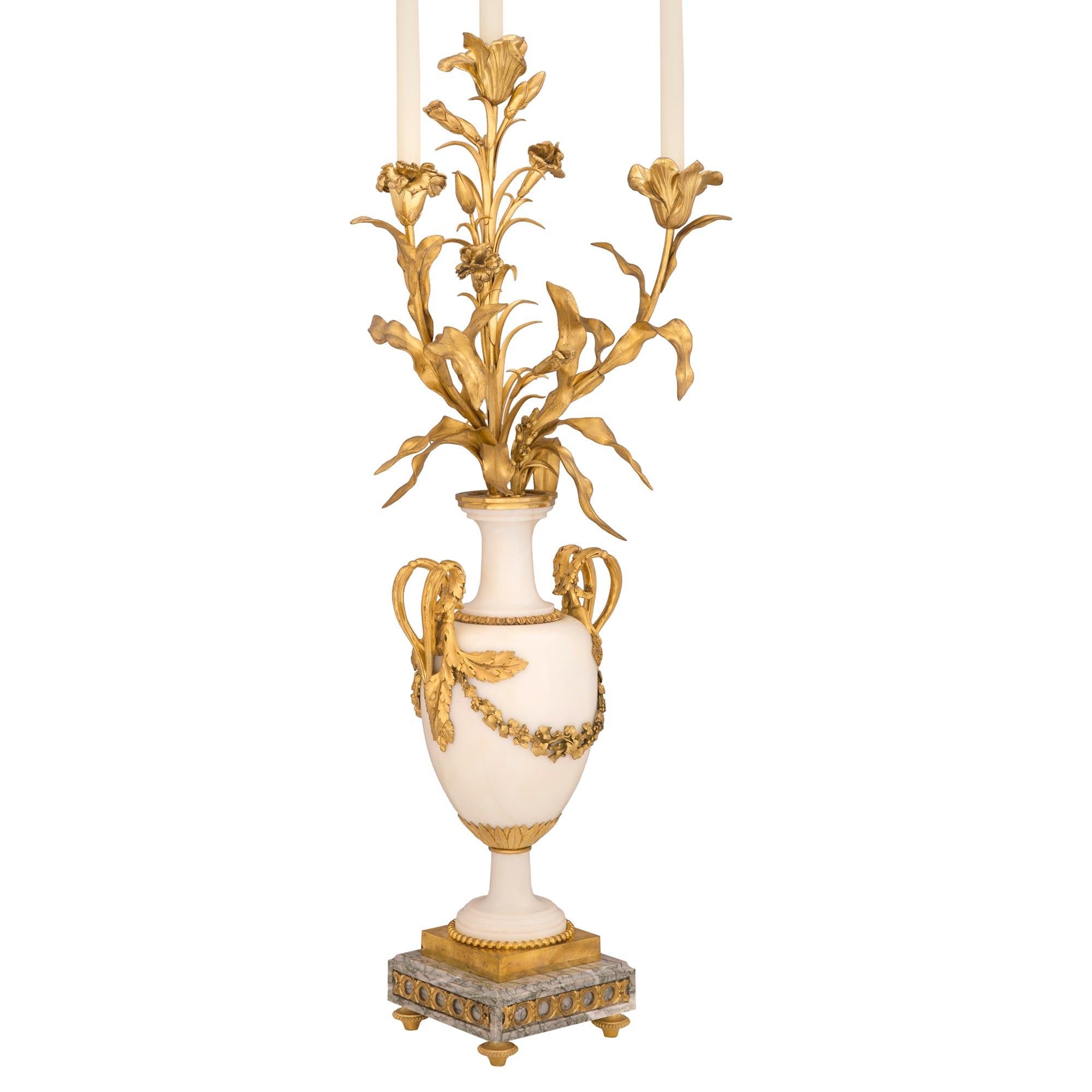An impressive and high quality pair of French 19th century Louis XVI st. Belle Époque period white Carrara, Vert Campan marble and ormolu candelabras. Each large scale three arm candelabra is raised by four fine ormolu topie shaped feet below the