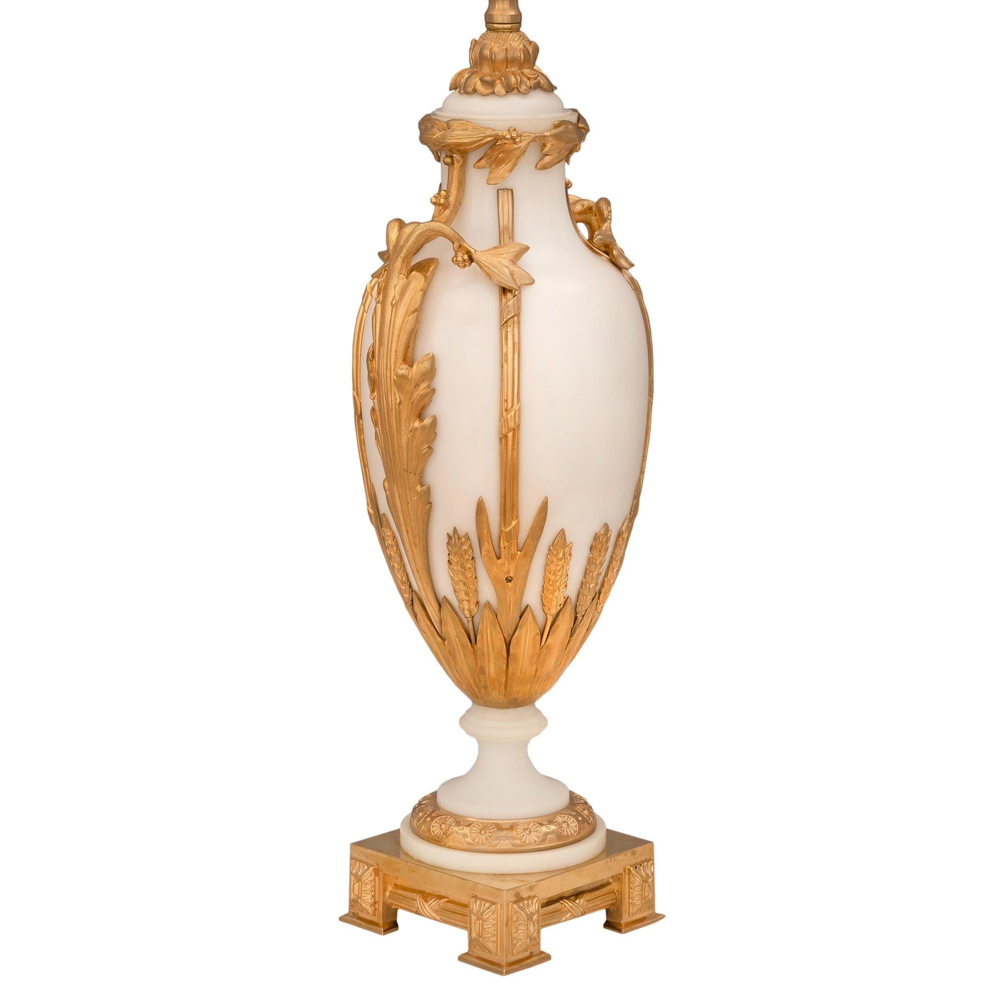 An impressive and extremely elegant pair of French 19th century Louis XVI st. white Carrara marble and ormolu lamps, attributed to A. Ermane. Each lamp is raised by a fine ormolu square base with four feet each displaying wonderful foliate block