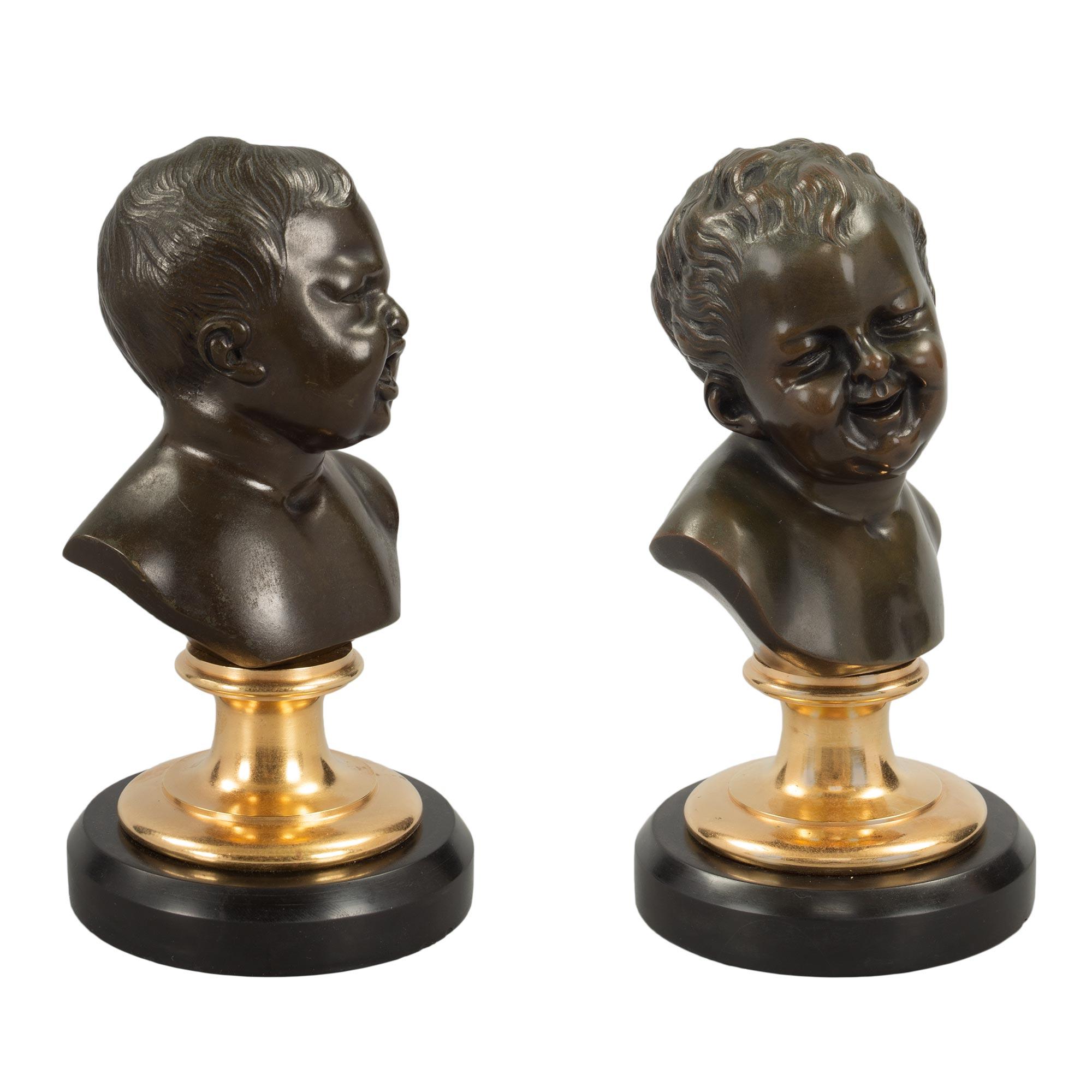 A charming true pair of French 19th century Louis XVI st. black Belgian marble, ormolu and patinated bronze statues of ‘Jean qui rit, Jean qui pleure’, Jean who laughs, Jean who cries. Each bronze is raised by a circular Black Belgian marble base