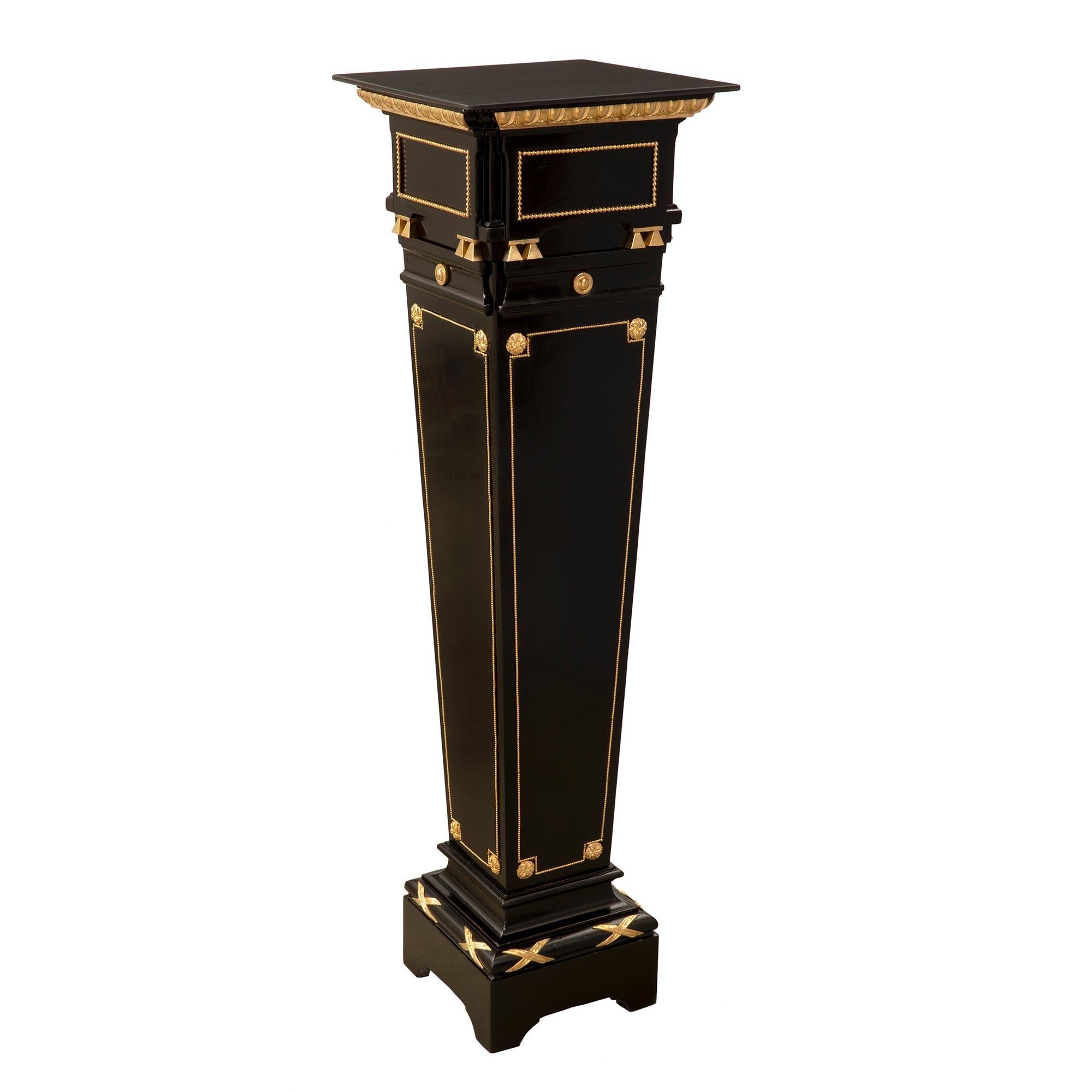 A most elegant pair of French mid 19th century Louis XVI st. Napoleon III period ebony, ormolu and black Belgian marble pedestals. The pair are raised by square bases with 'X' shaped ormolu mounts. Above are the tapered columns with central recessed
