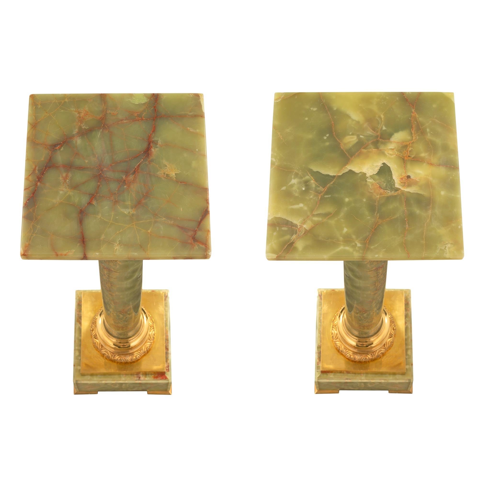 A stunning and extremely elegant pair of French 19th century Louis XVI st. onyx and ormolu pedestal columns. Each pedestal is raised by fine ormolu supports below the square onyx base with a lovely mottled border. The circular onyx central support