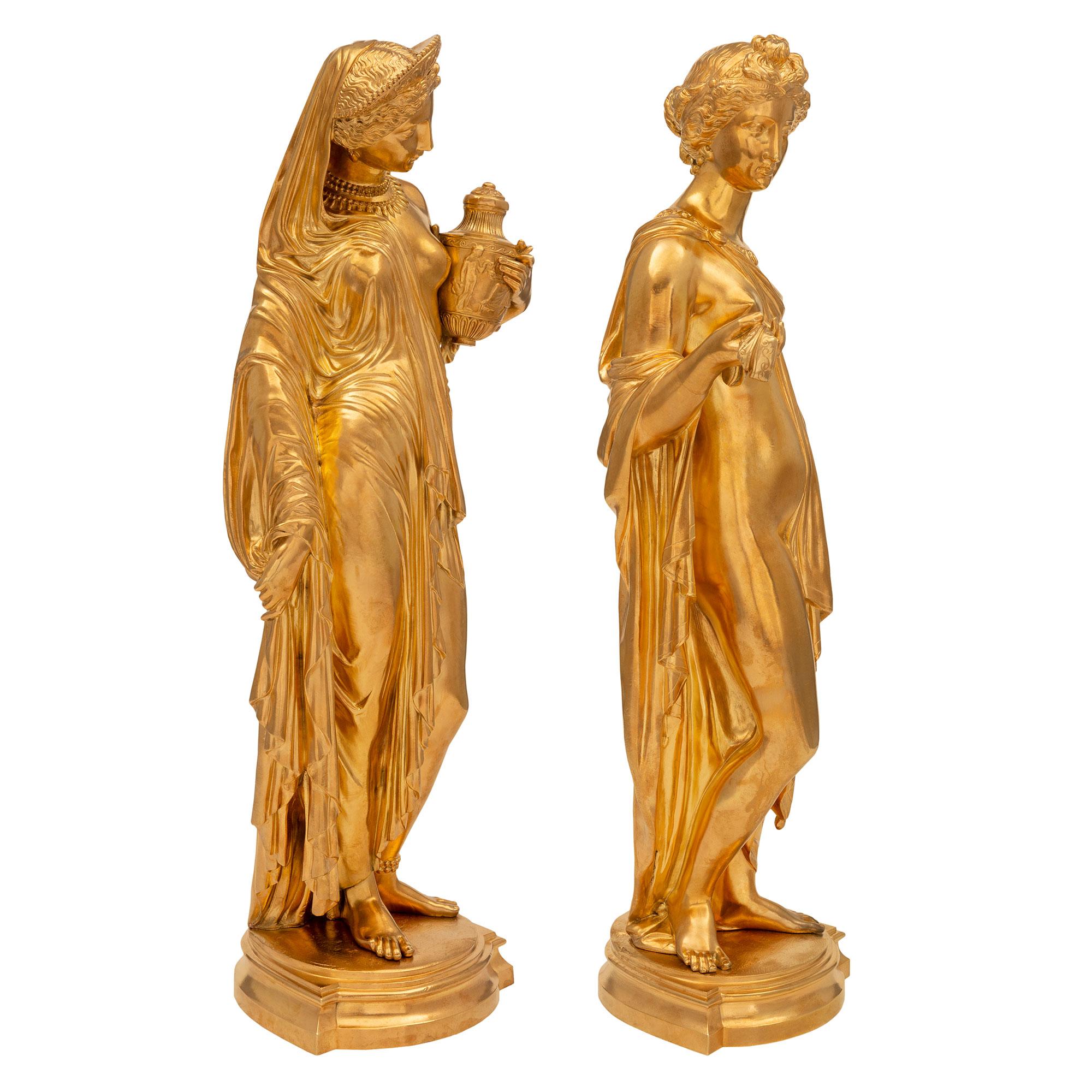 An outstanding pair of French 19th century Louis XVI st. ormolu statues. Each statue is raised by an elegant mottled base with fine rounded borders. The beautiful maidens above are each are dressed in wonderfully executed period garments draped over