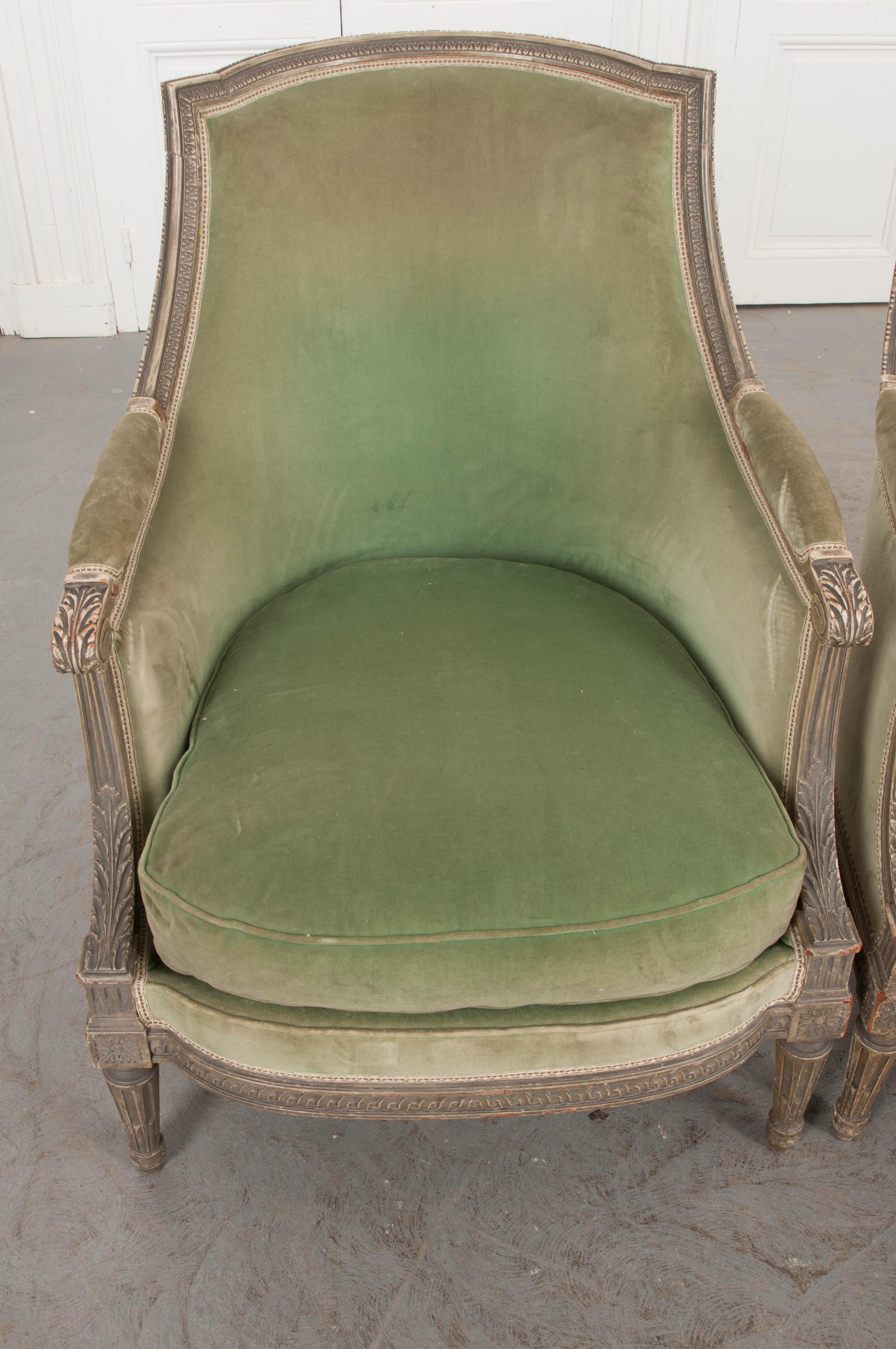 This stately pair of Louis XVI-style bergères are from 1870s France. Of generous proportion, the delicately carved wood displays its original cream paint. These elegant chairs have been upholstered in a lovely spring-green velvet and are sure to