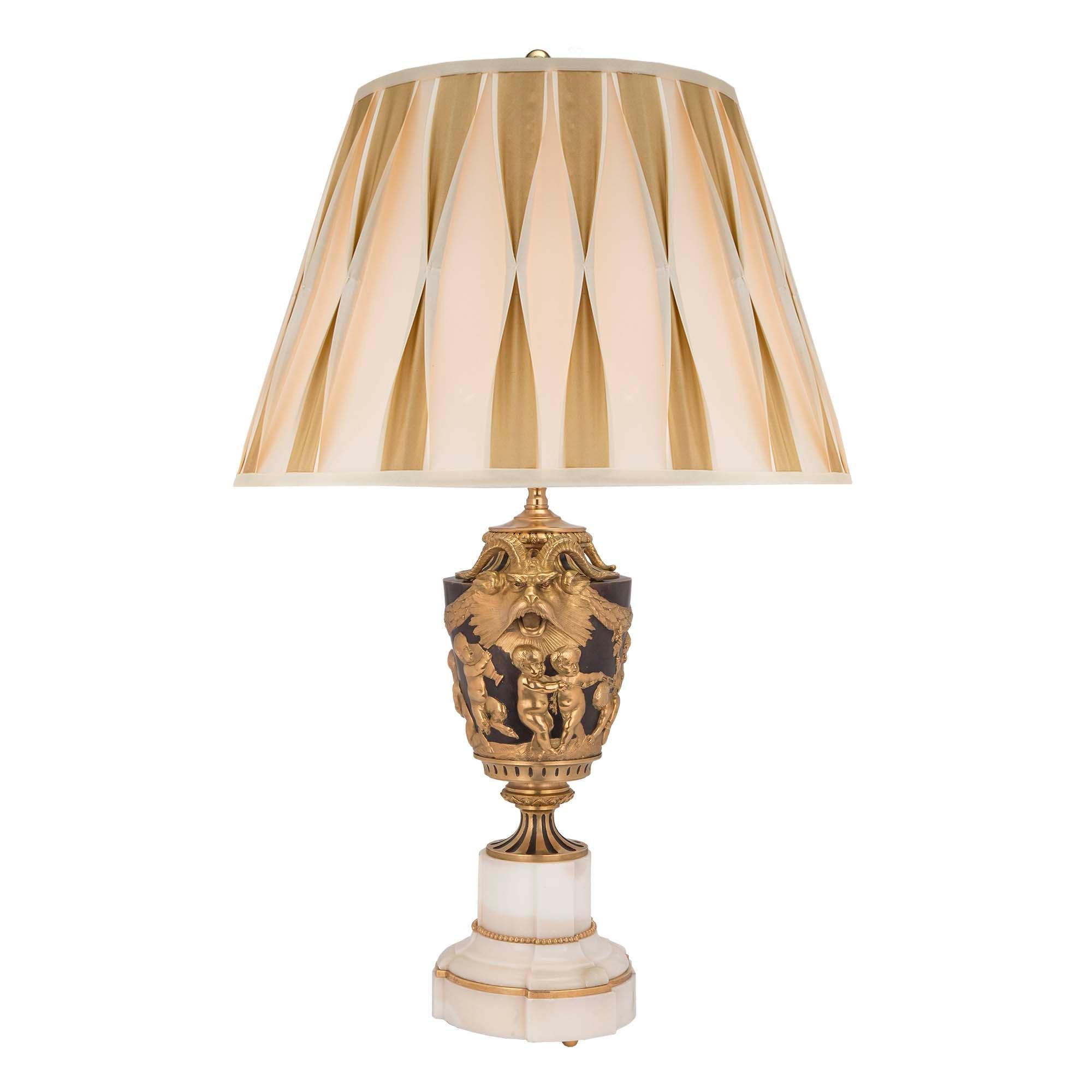 A most elegant pair of French 19th century Louis XVI st. patinated bronze and ormolu lamps after a model by John Flaxman. Each lamp is raised by ormolu ball feet and a solid white Carrara marble base, with cut sides, a mottled design and decorative