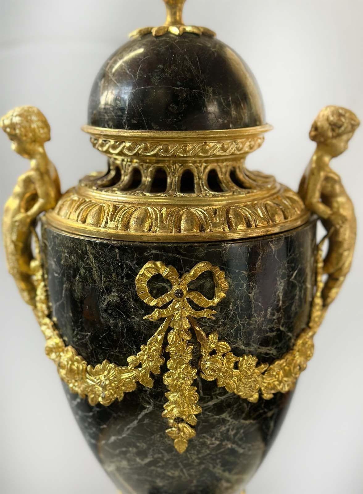 Zwei Urnen aus Bronze und dunklem Verde-Antico-Marmor im Louis-XVI-Stil, die im 19. Jahrhundert in Frankreich hergestellt wurden. Auf der Oberseite jeder Urne befindet sich ein zierlicher Tannenzapfen aus Bronze, und die Urnen sind mit zwei
