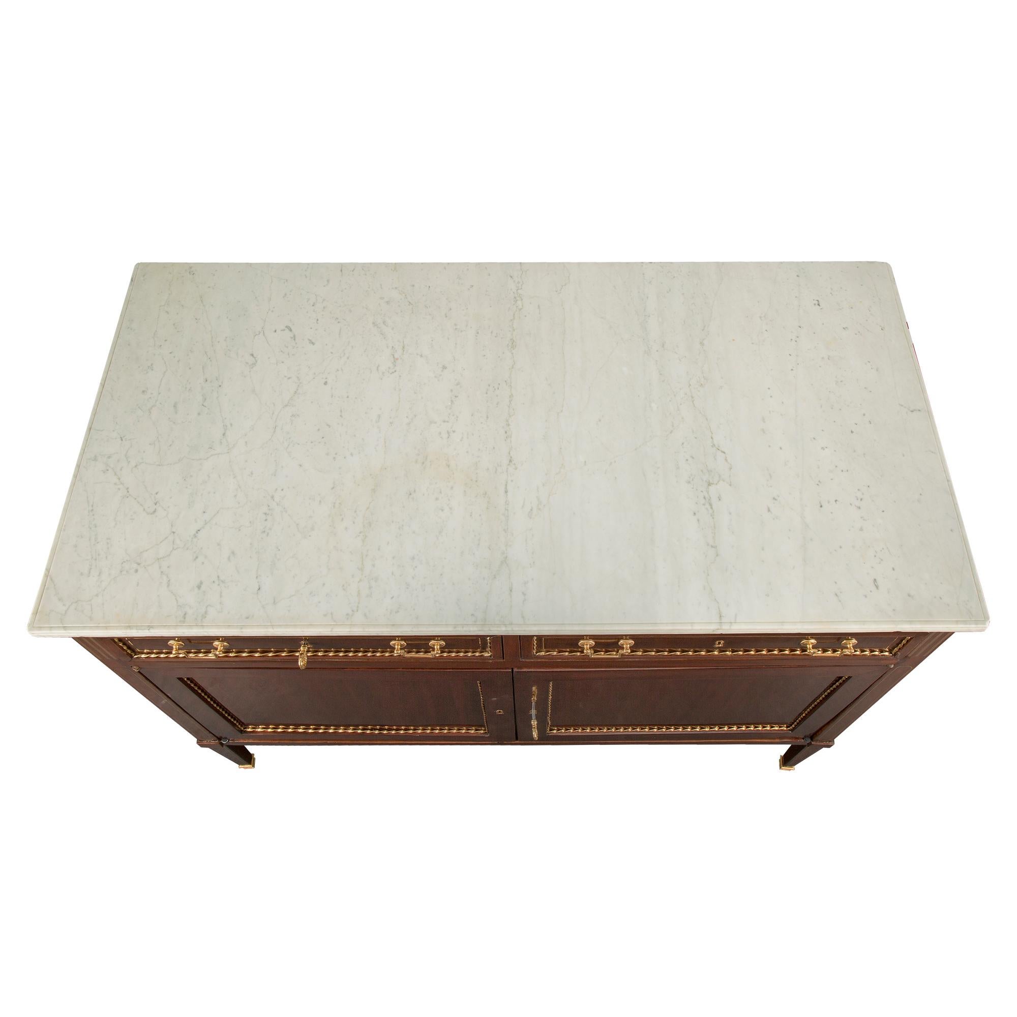 Un'elegante e rara coppia di buffet italiani del XVIII secolo di epoca Luigi XVI in mogano, ormolu, ottone e marmo. Ogni buffet è sollevato da gambe quadrate affusolate con sabot avvolgenti in ormolu ed eleganti filetti intarsiati in ottone. Al