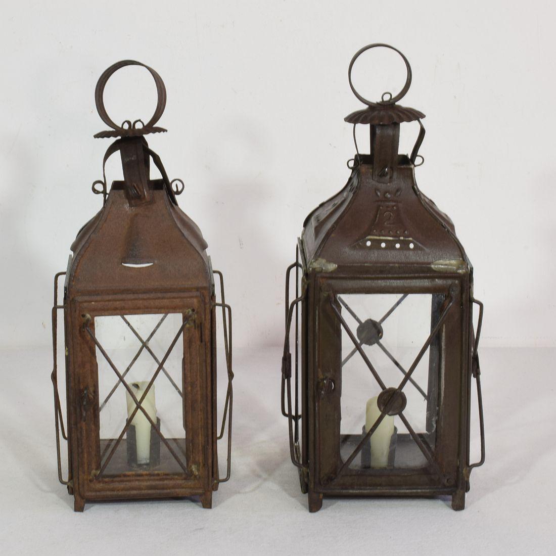 Nice pair of metal lanterns, France, circa 1850-1900.
Weathered and old repairs ( glass once replaced )
Measures: H:30-31cm W:12-13cm D:12-13cm 
Measurement here below of the largest lantern.