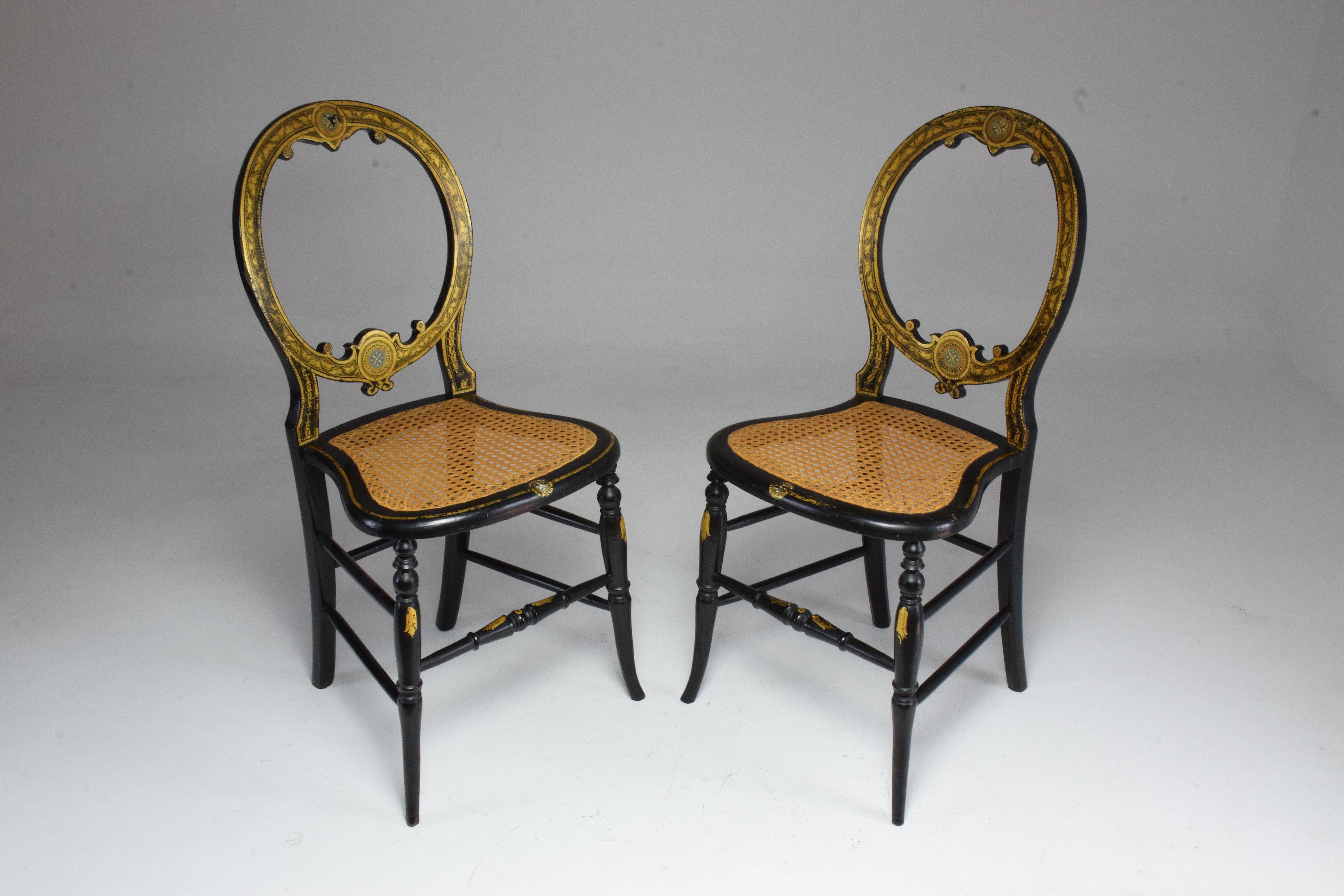 Set of two French antique chairs from the Napoleon III era in neoclassical style in ebonized mahogany and giltwood. A charming pair of side, accent or salon chairs in their original cane seats of beautiful condition and medallion shaped