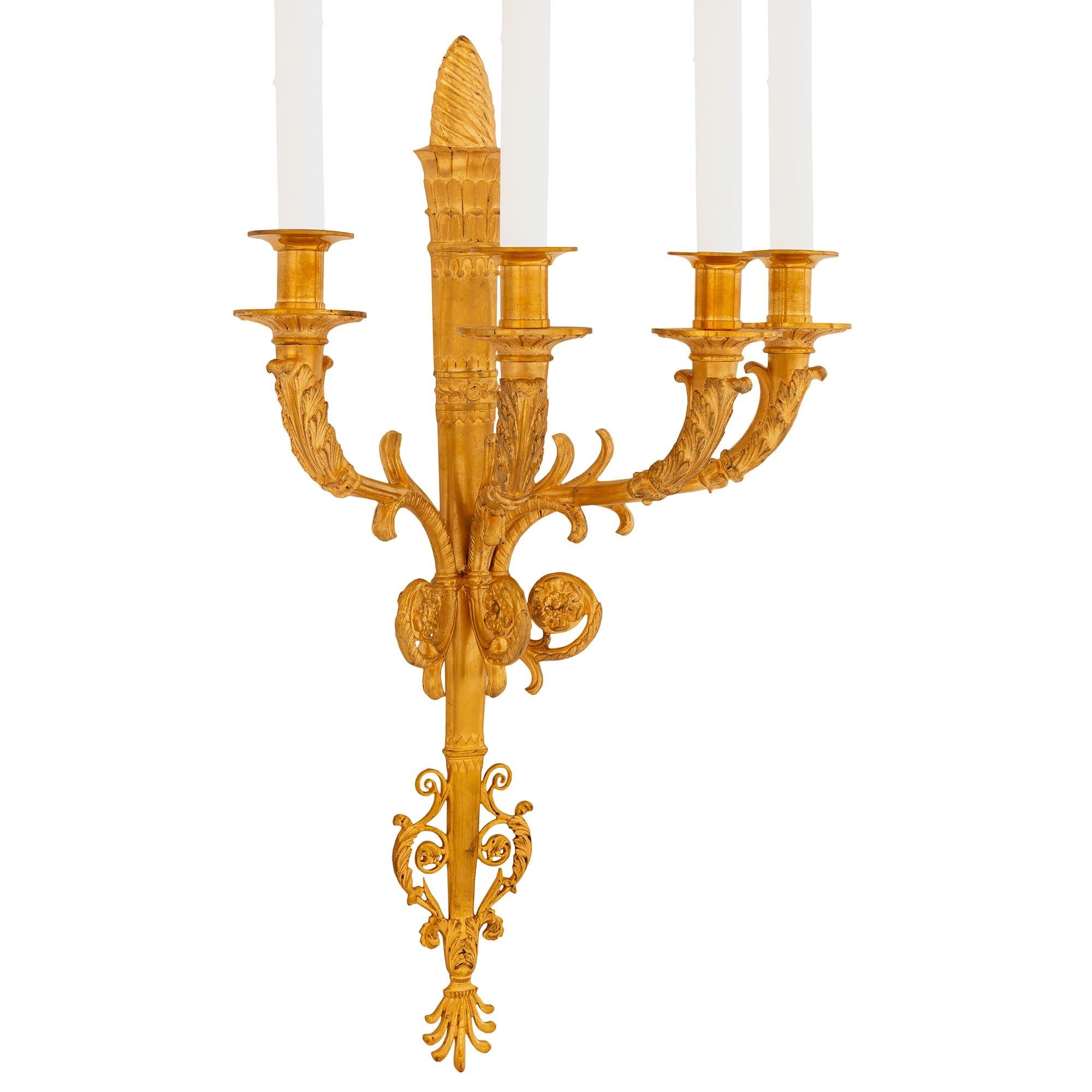 An elegant pair of French 19th century Neo-Classical st. four arm ormolu sconces. Each sconce is centered by a fine bottom palmette designed finial below most decorative scrolled foliate and Rinceau foliate designs. The tapered central fut is in the