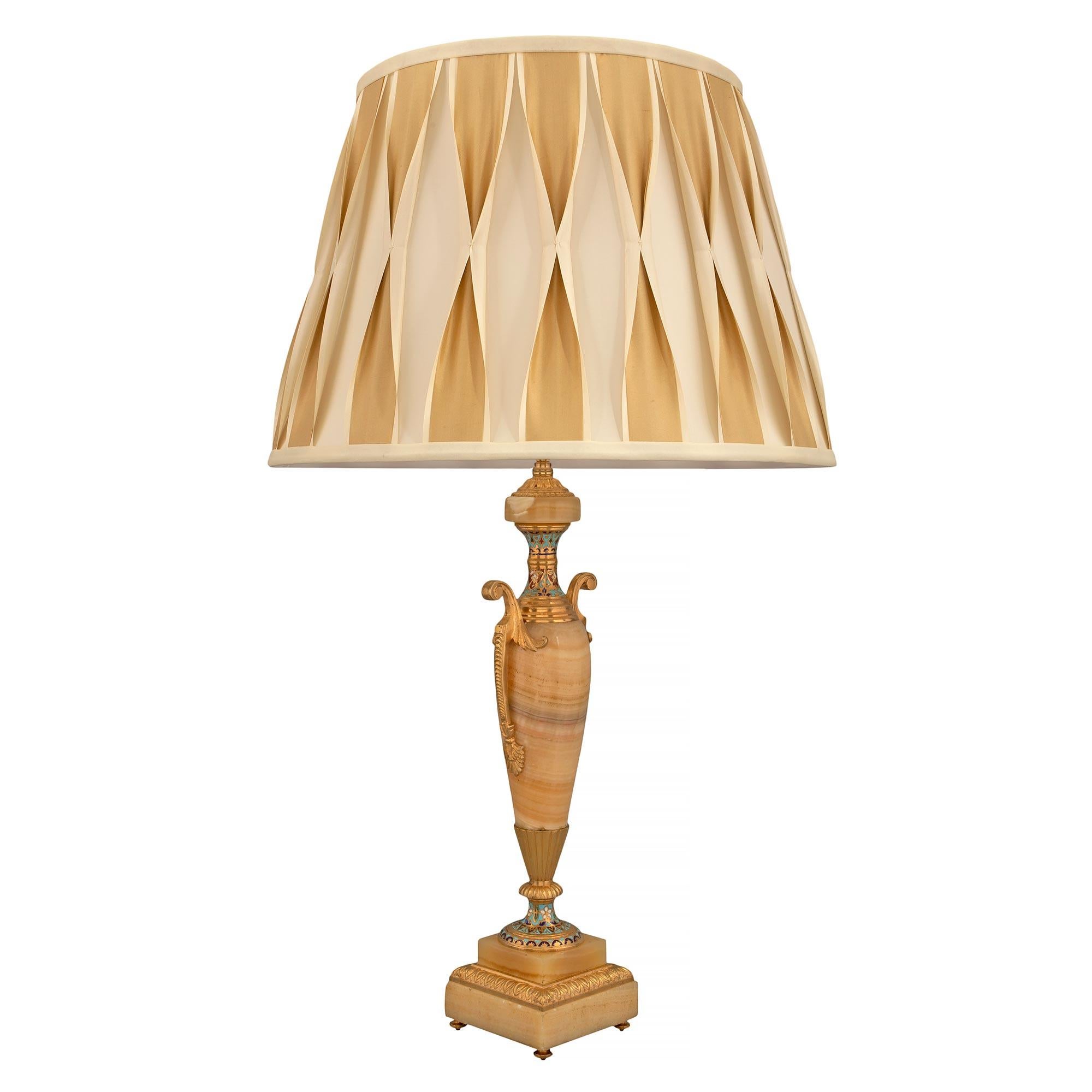 Paire de lampes néoclassiques françaises du 19ème siècle en onyx, bronze doré et cloisonné. Chaque lampe est surélevée par de fins pieds en forme de topie en bronze doré sous la base carrée en onyx avec une élégante bande enveloppante en bronze doré