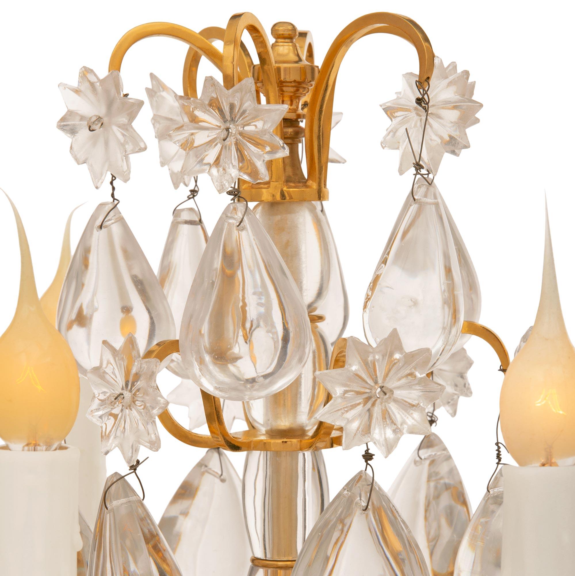 A stunning pair of French 19th century Neo-Classical Period Louis XIV st. Ormolu and Baccarat crystal candelabras lamps. Each six arm candelabra is raised on a triangular base with three delicately tapered fluted feet below exceptional richly chased