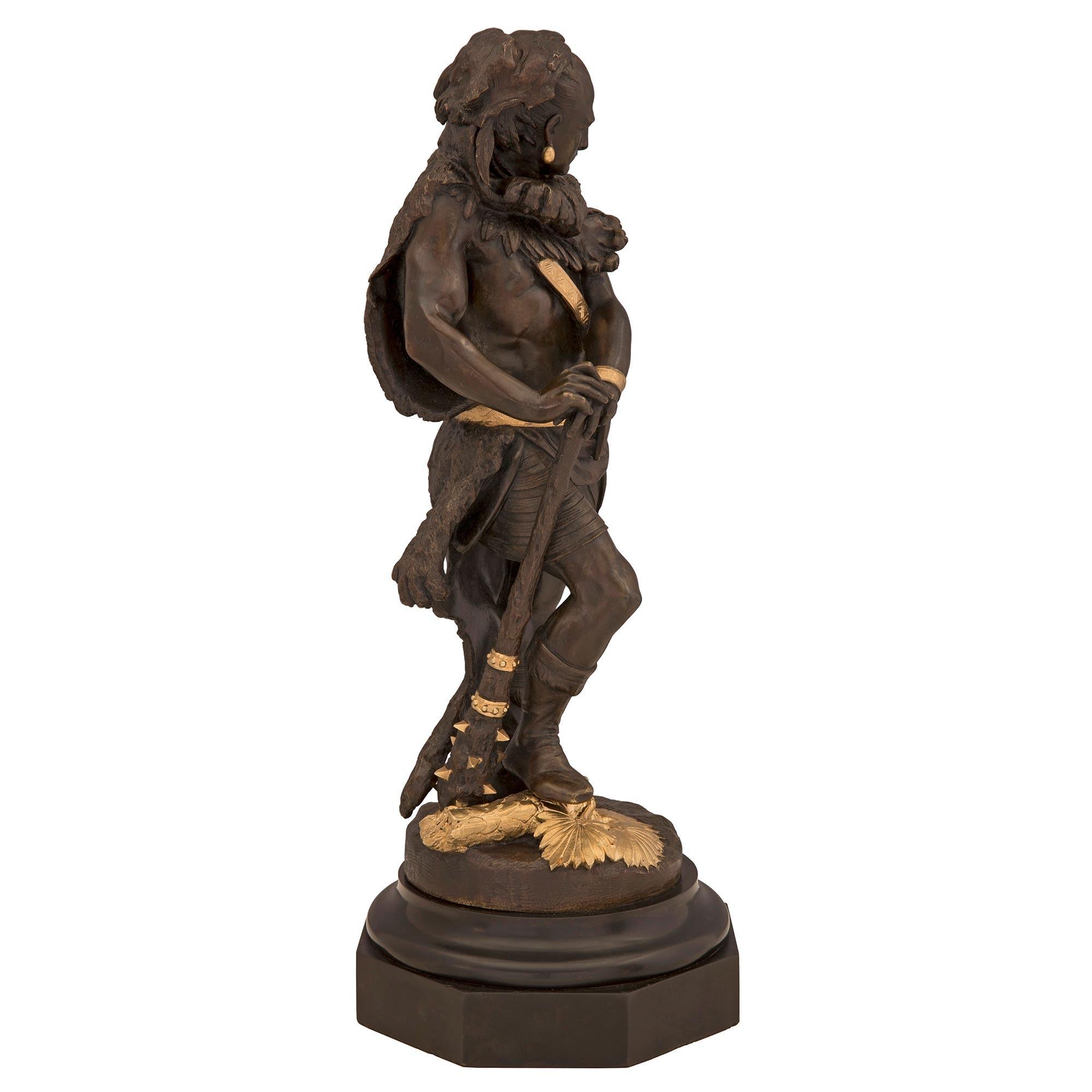 A striking and very high quality pair of French 19th century neo-classical st. patinated bronze and ormolu statues. The statues depict hunter gatherers/explorers and are each raised by an elegant octagonal and mottled base. The statue to the left