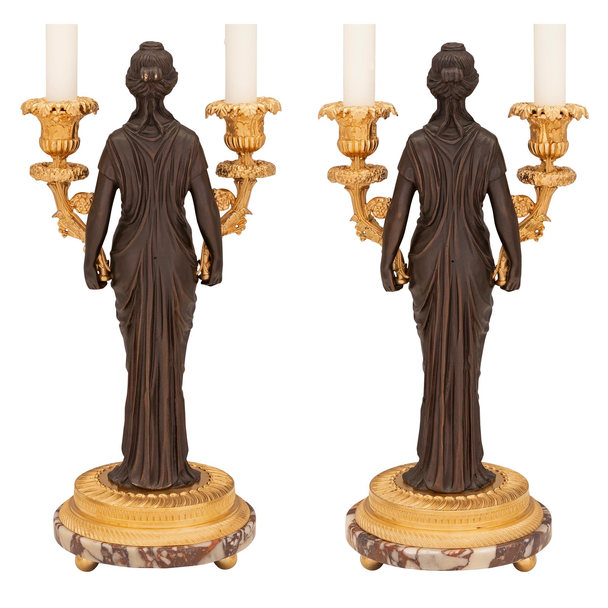 A striking pair of French 19th century neo-classical st. patinated bronze, ormolu and Brèche de Appenninica marble candelabra lamps. Each two armed lamp is raised by a beautiful circular Brèche de Appenninica marble base with fine ormolu ball feet