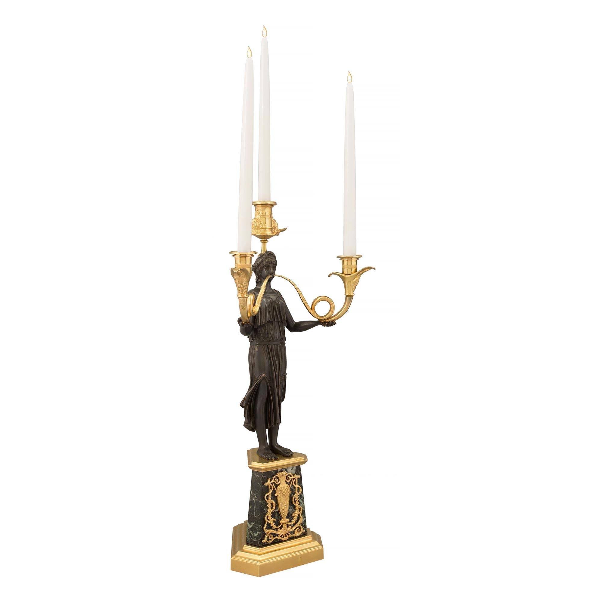 An extremely elegant and high quality pair of French 19th century Neo-Classical st. patinated bronze, ormolu and marble, three arm candelabras. Each candelabra is raised by a triangular ormolu base with cut corners and a fine stepped design. The