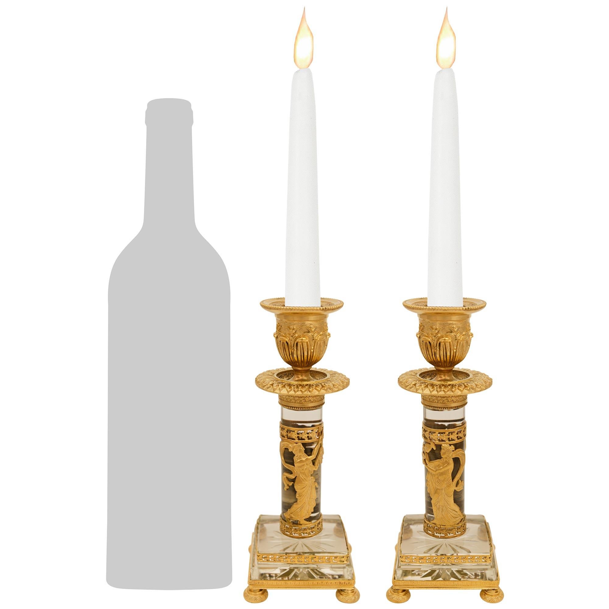 Ein elegantes und sehr dekoratives Paar französischer neoklassizistischer Kerzenleuchter aus dem 19. Ormolu und Kristall Leuchter. Jeder charmante Kerzenhalter steht auf blattförmigen Ormolu-Füßen unter einem Lorbeerband, das den quadratischen