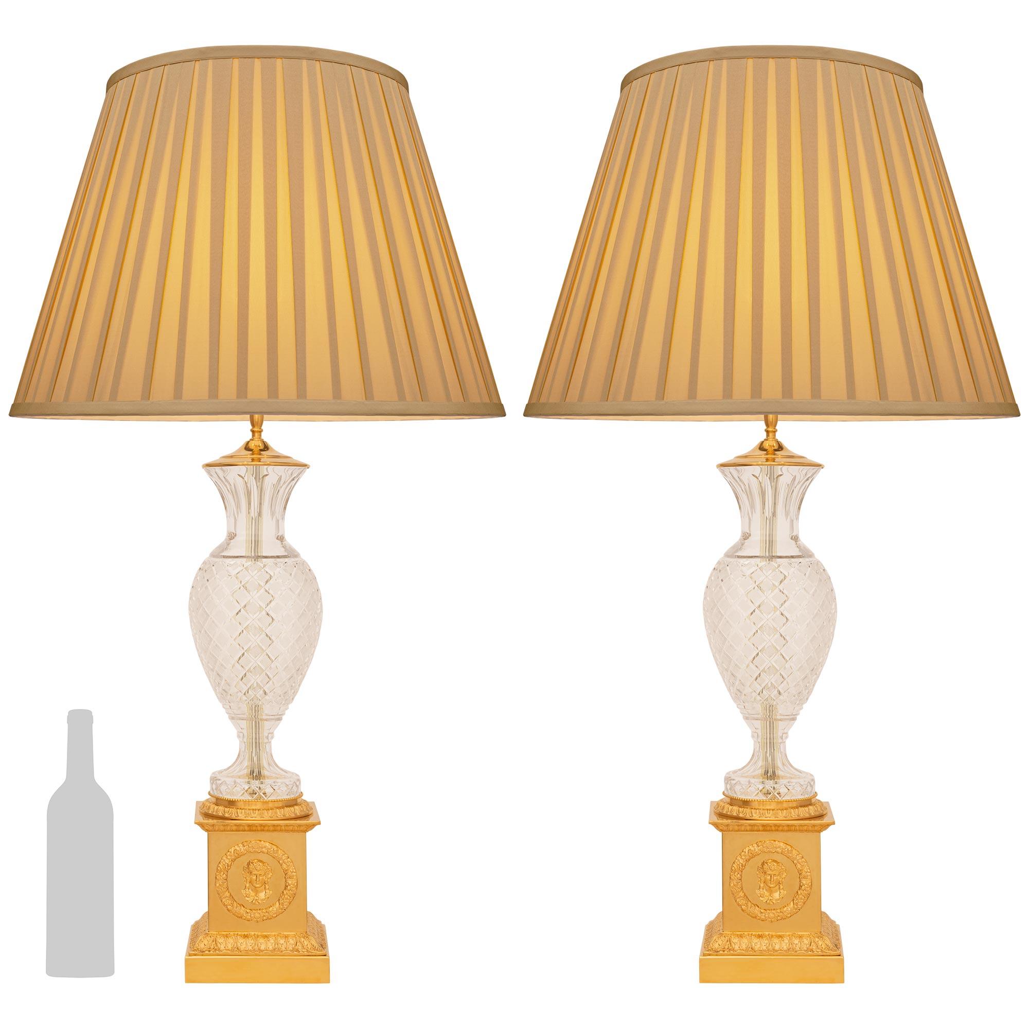 Atractiva y muy decorativa pareja de lámparas francesas del siglo XIX de estilo neoclásico. Ormolu y lámparas de cristal. Cada preciosa lámpara se eleva sobre una base cuadrada de Ormolu con una banda de diseño Coeur-de-Rai alrededor del plinto,