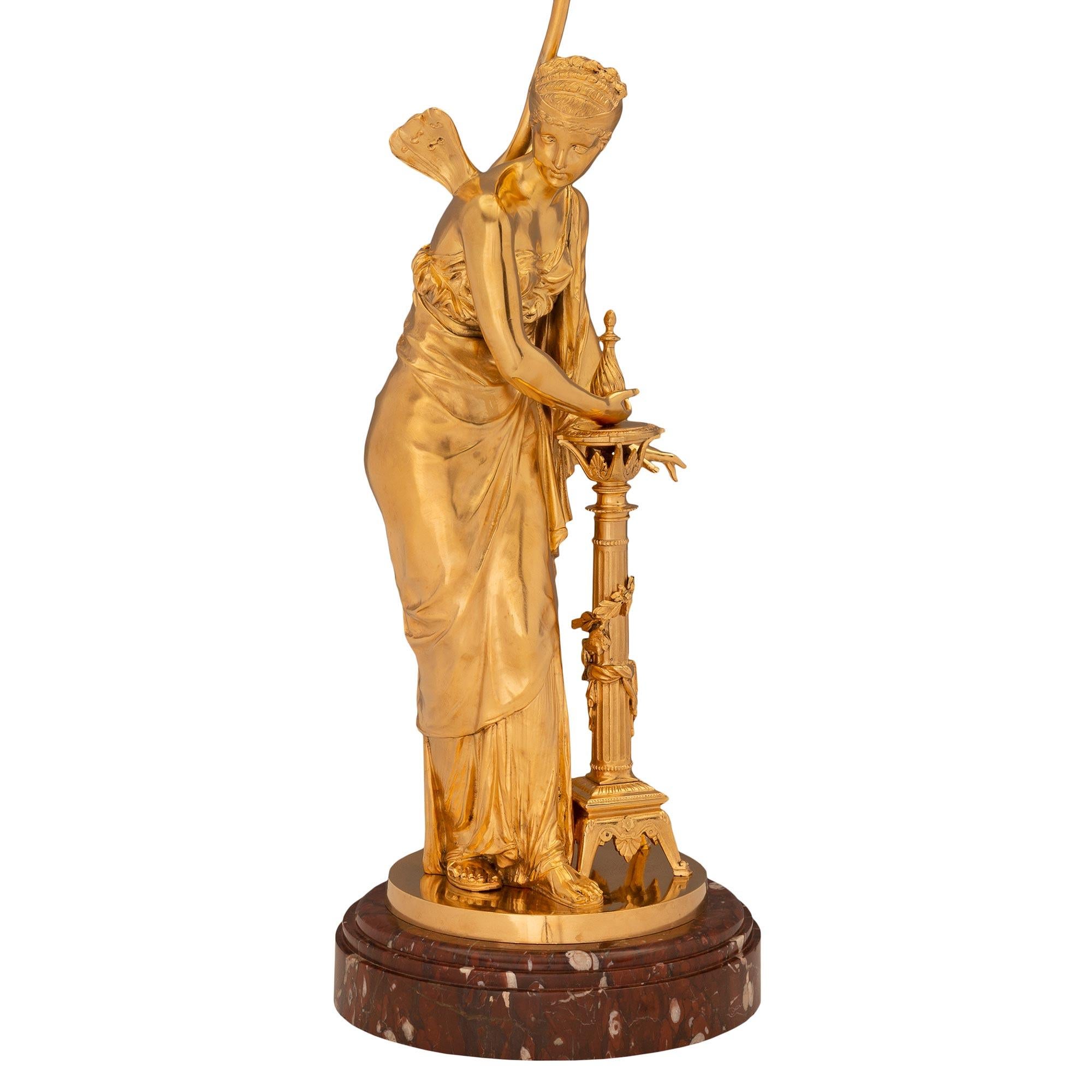 Une exceptionnelle et très charmante paire de lampes néo-classiques françaises du 19ème siècle en bronze doré et marbre Rouge Griotte. Chaque lampe est surélevée par son élégante base circulaire d'origine en marbre Rouge Griotte avec un fin