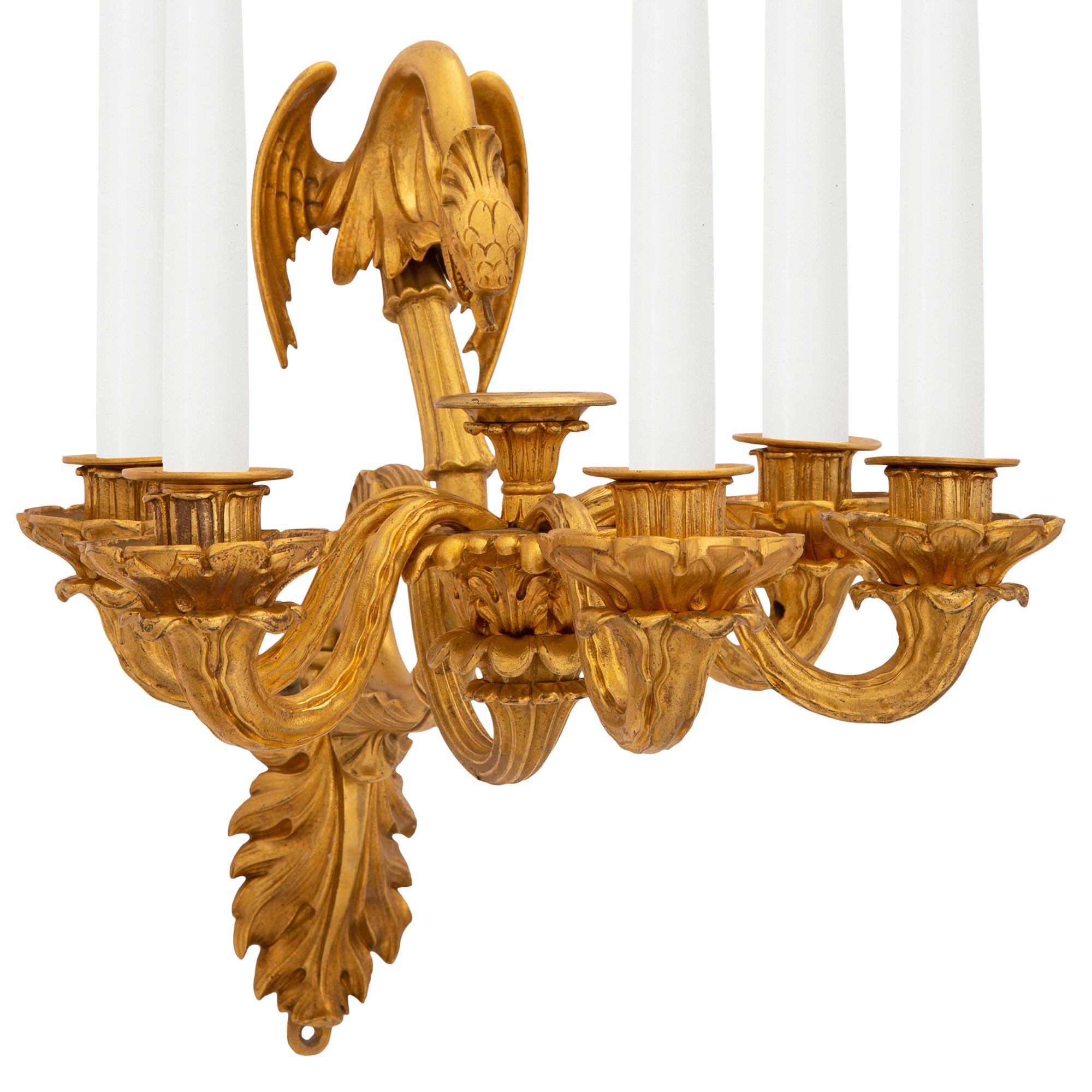 Paire d'appliques néo-classiques en stuc et bronze doré de grande qualité, datant du XIXe siècle. Chaque applique à cinq bras est centrée par une exceptionnelle plaque arrière feuillagée d'où partent les élégants supports à volutes. Les magnifiques