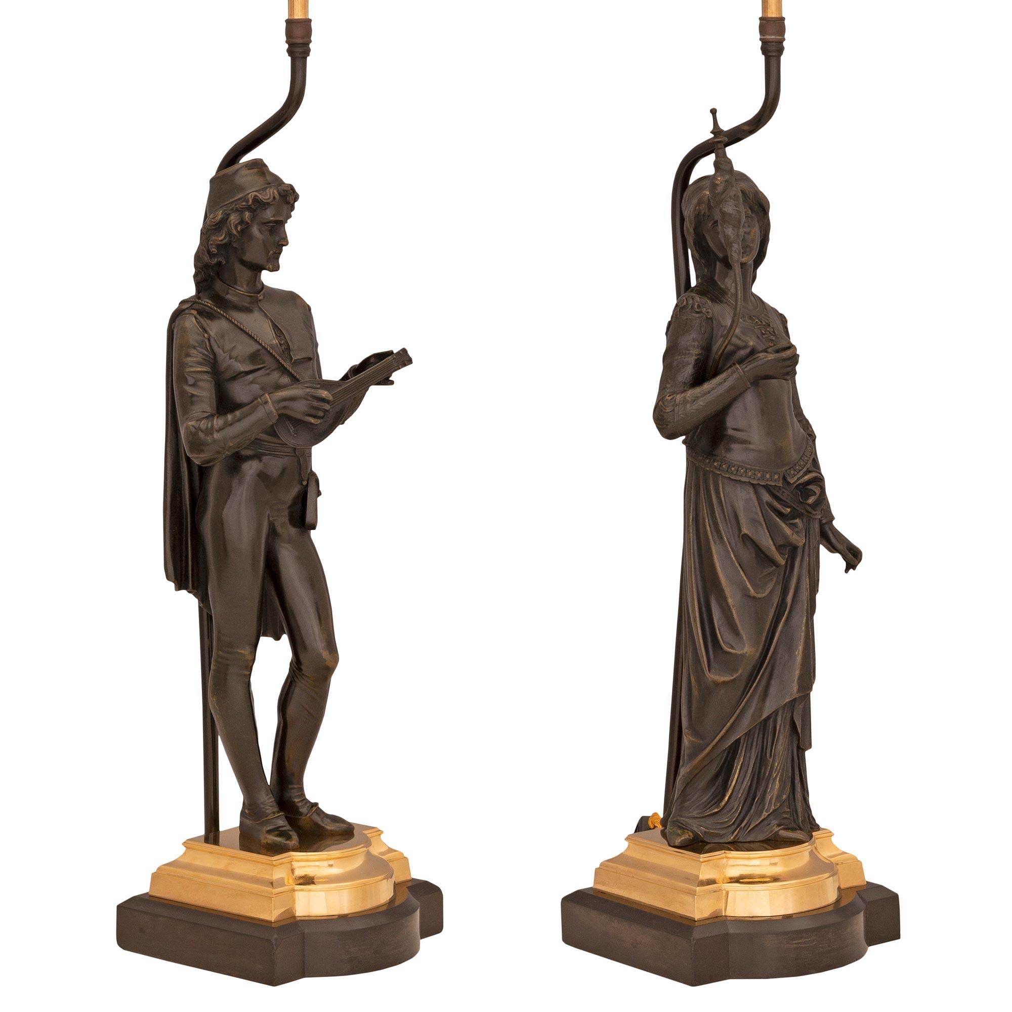 A beautiful and high quality true pair of French 19th century Neo-Classical st. patinated bronze and ormolu lamps. Each lamp is raised by fine patinated bronze and ormolu bases with convex fronts and elegant stepped mottled designs. To the left is a