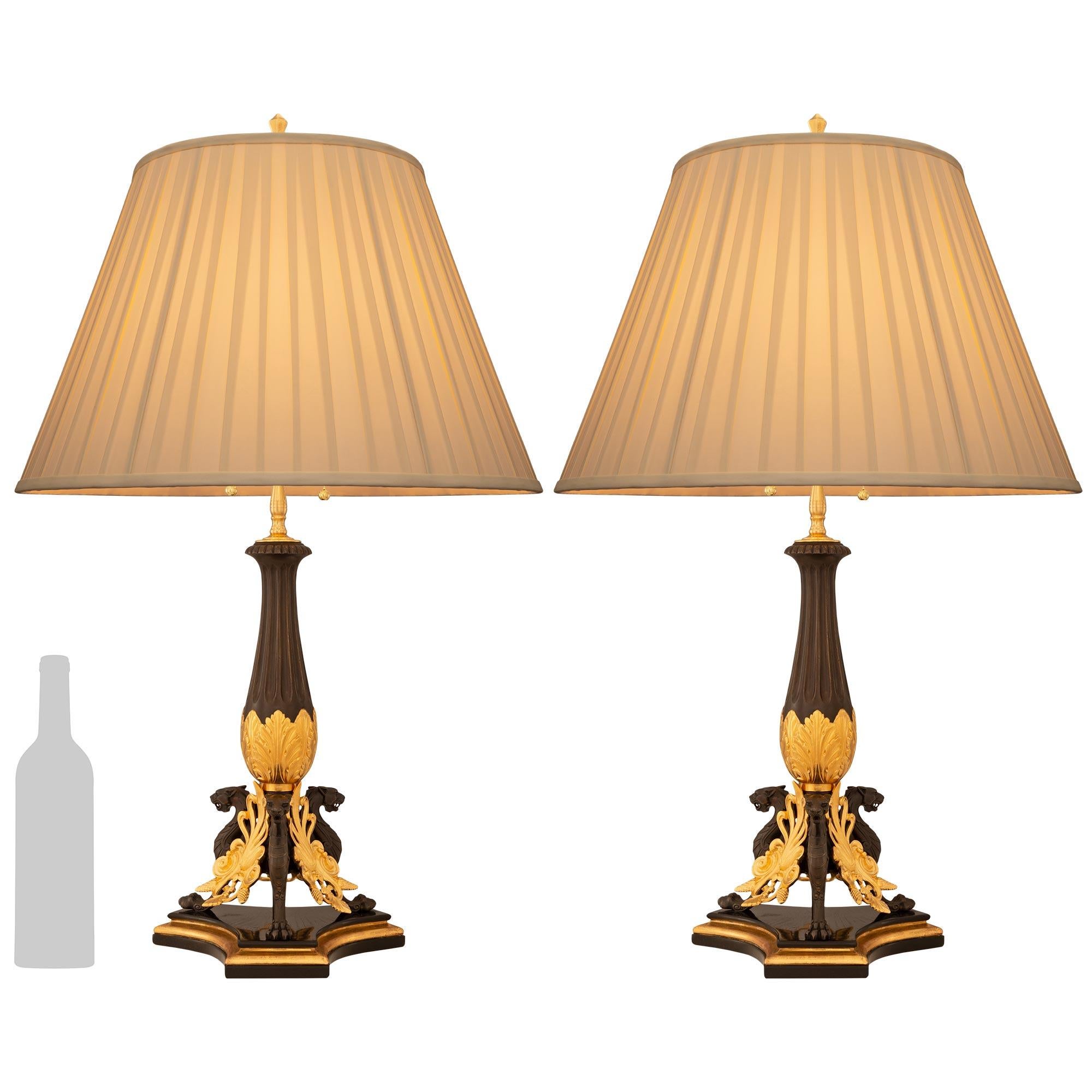 A very elegant and finely detailed pair of French 19th century Neo-Greek st. ebonized Fruitwood, Giltwood, patinated Bronze, and Ormolu lamps. Each stunning lamp is raised by three panthers with paw feet and each separated by wonderful pierced