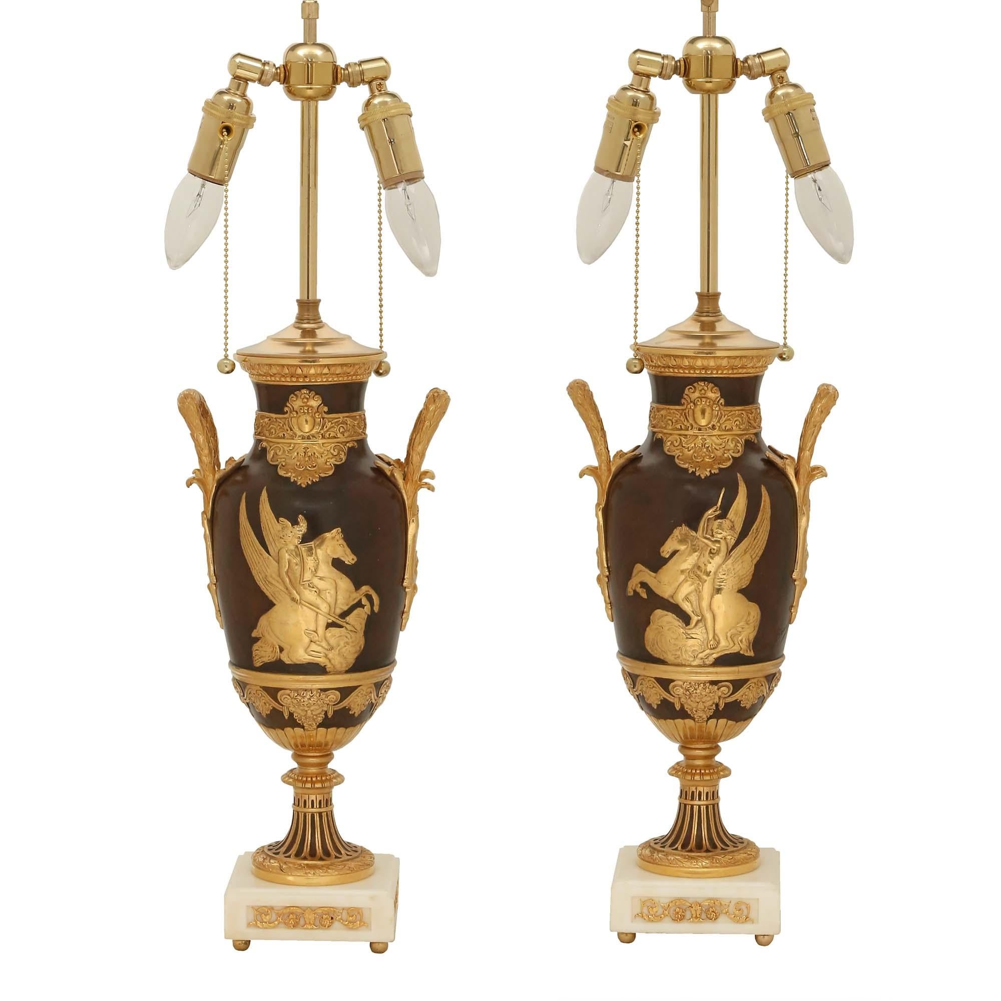 A stunning true pair of French 19th century Neo-Classical st. patinated bronze, ormolu and marble urns mounted into lamps, signed LÉON BOUCHER. Each lamp is raised by a square white Carrara marble base with ormolu ball feet and an elegant pierced