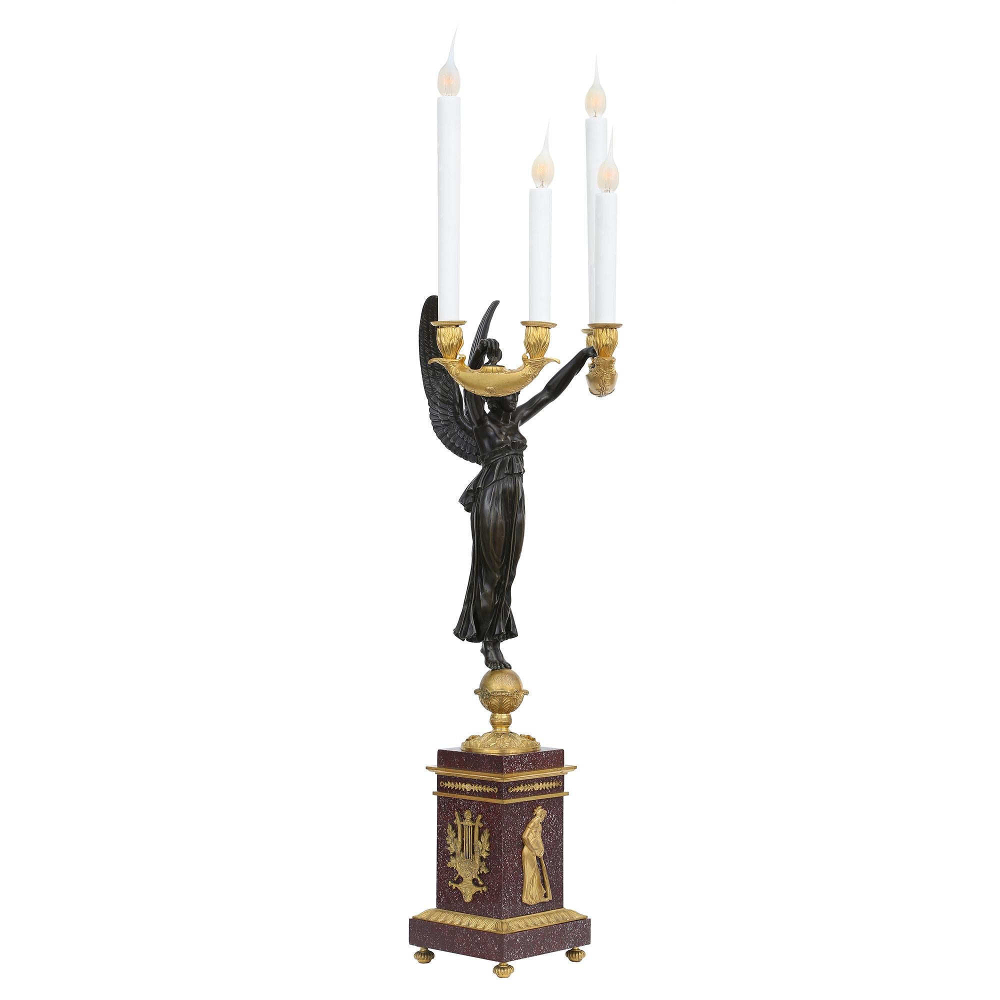 A sensational and extremely high quality true pair of French 19th century neo-slassical st. ormolu, patinated bronze and Porphyry electrified candelabras Aux Victoires. Each candelabra is raised by four reeded topie shaped feet below the Porphyry