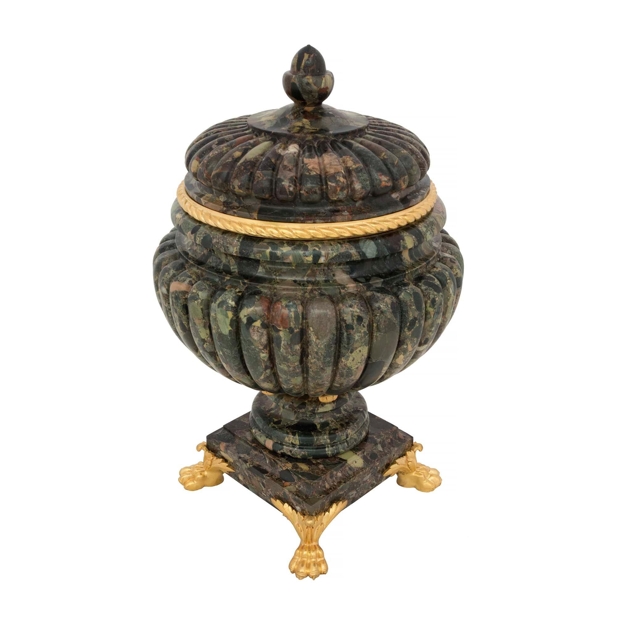 An exceptional pair of French 19th century neo-classical st. Brèche Verte d'Egypte marble and ormolu lidded urns. Each urn is raised by richly chased ormolu paw feet with acanthus leaf detail. Above the square mottled base and circular socle