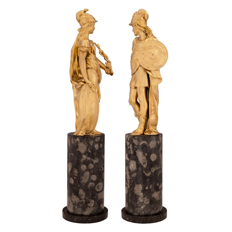 A striking and high quality pair of French 19th century Neo-Classical st. ormolu, black Porphyry and fossilized marble statues of Minerva and Hermes. Each statue is raised by a beautiful circular fossilized marble base with an elegant bottom black