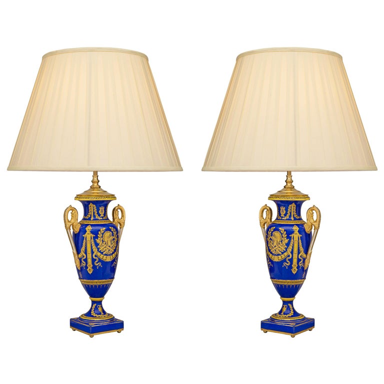 A stunning true pair of French 19th century Neo-Classical st. cobalt blue and gilt porcelain vases mounted into lamps, possibly by Sèvres. Each lamp is raised by fine ormolu ball feet, below a square base and socle pedestal, decorated with a lovely