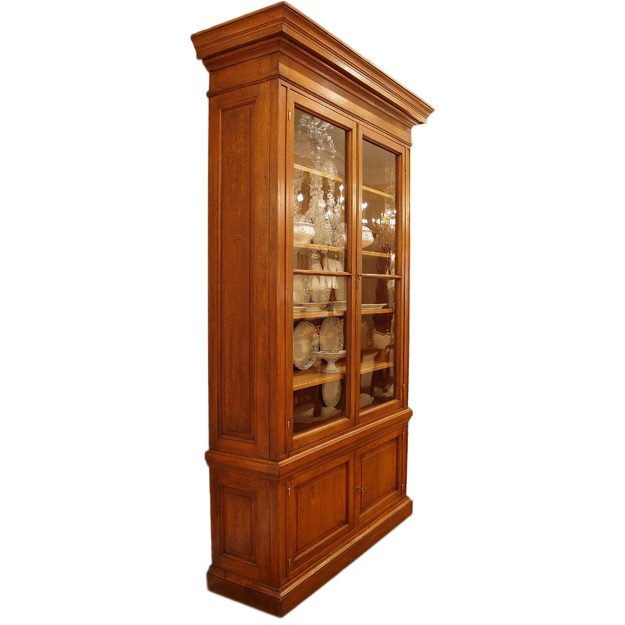 A most impressive and large scale pair of French 19th century oak cabinets. The banded lower part with a moulded edge has two paneled doors on a plinth base. The upper part with a moulded cornice crown is fitted with two shelves and enclosed by