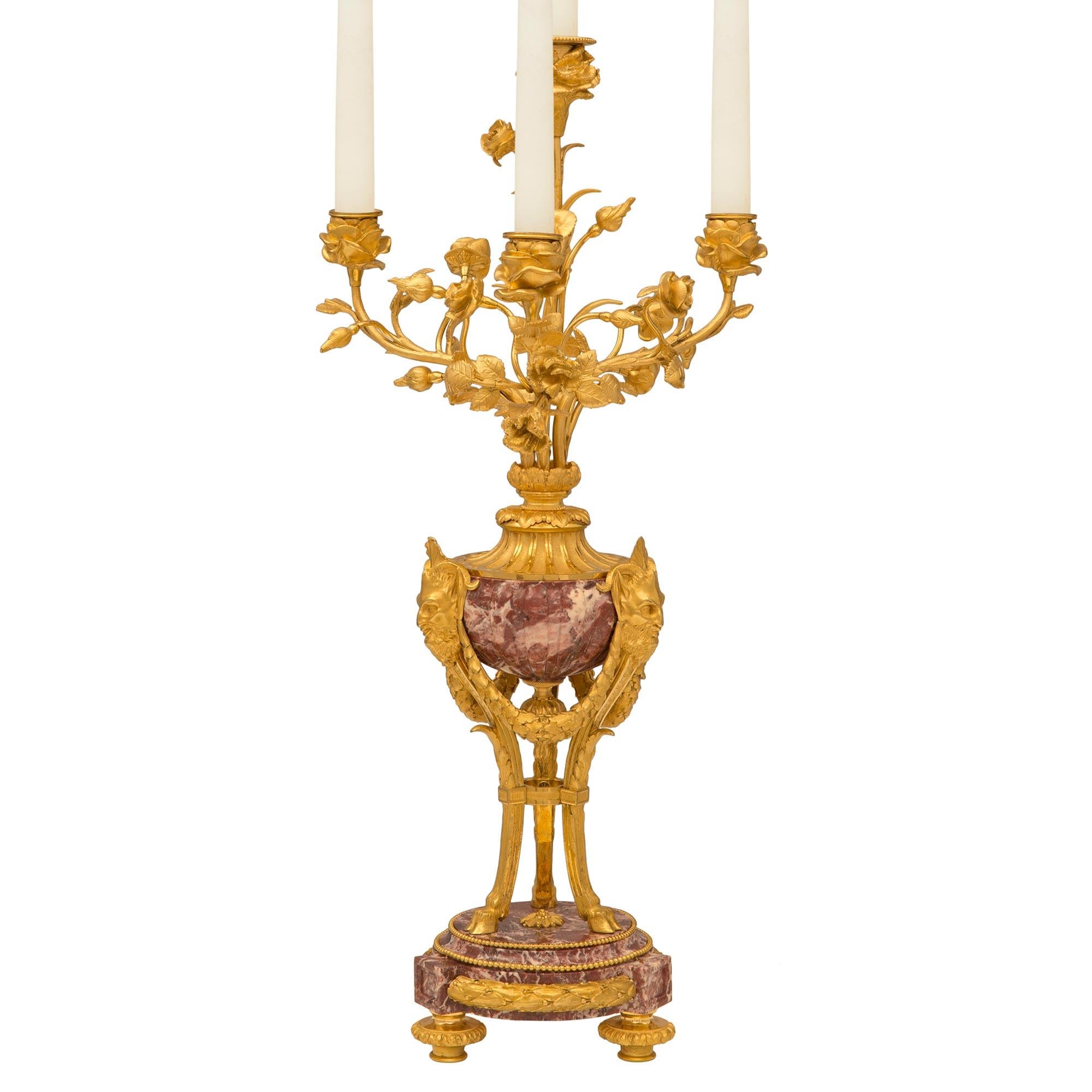 A beautiful and extremely high quality pair of French 19th century Louis XVI st. ormolu and Fleur de Pêcher marble candelabras. Each four arm candelabra is raised by three ormolu topie shaped feet below the exceptional double mottled circular Fleur