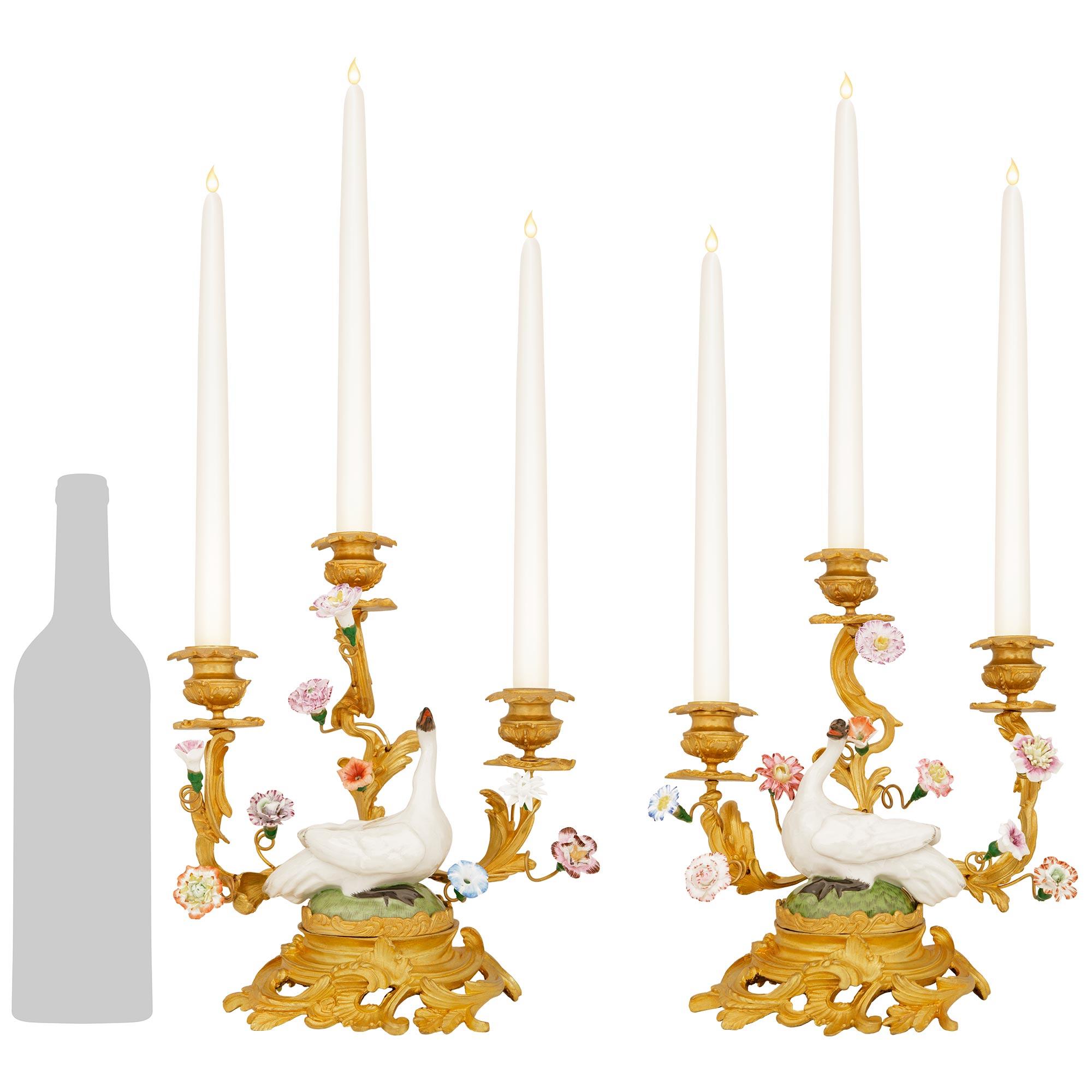 An exquisite and true pair of French 19th century Louis XV st. Ormolu and Meissen Porcelain candelabras. This elegant pair of three arm candelabras are raised by a circular pierced Ormolu bases with stunning foliate scrolls. At each center above