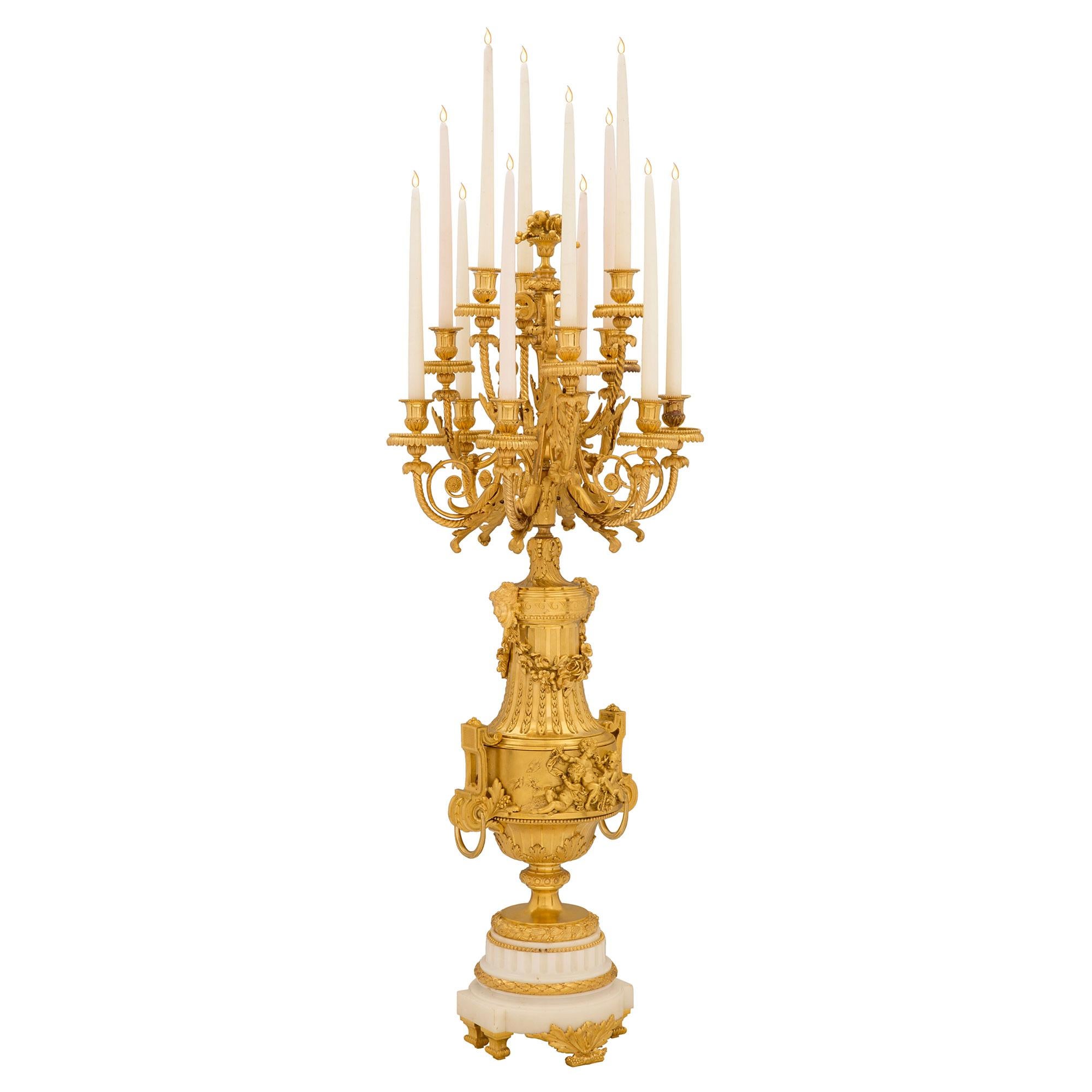 A stunning and extremely high quality pair of French 19th century ormolu and white Carrara marble candelabras. Each monumentally scaled candelabra is raised by elegant foliate feet and a white Carrara marble support. The supports display fine fluted