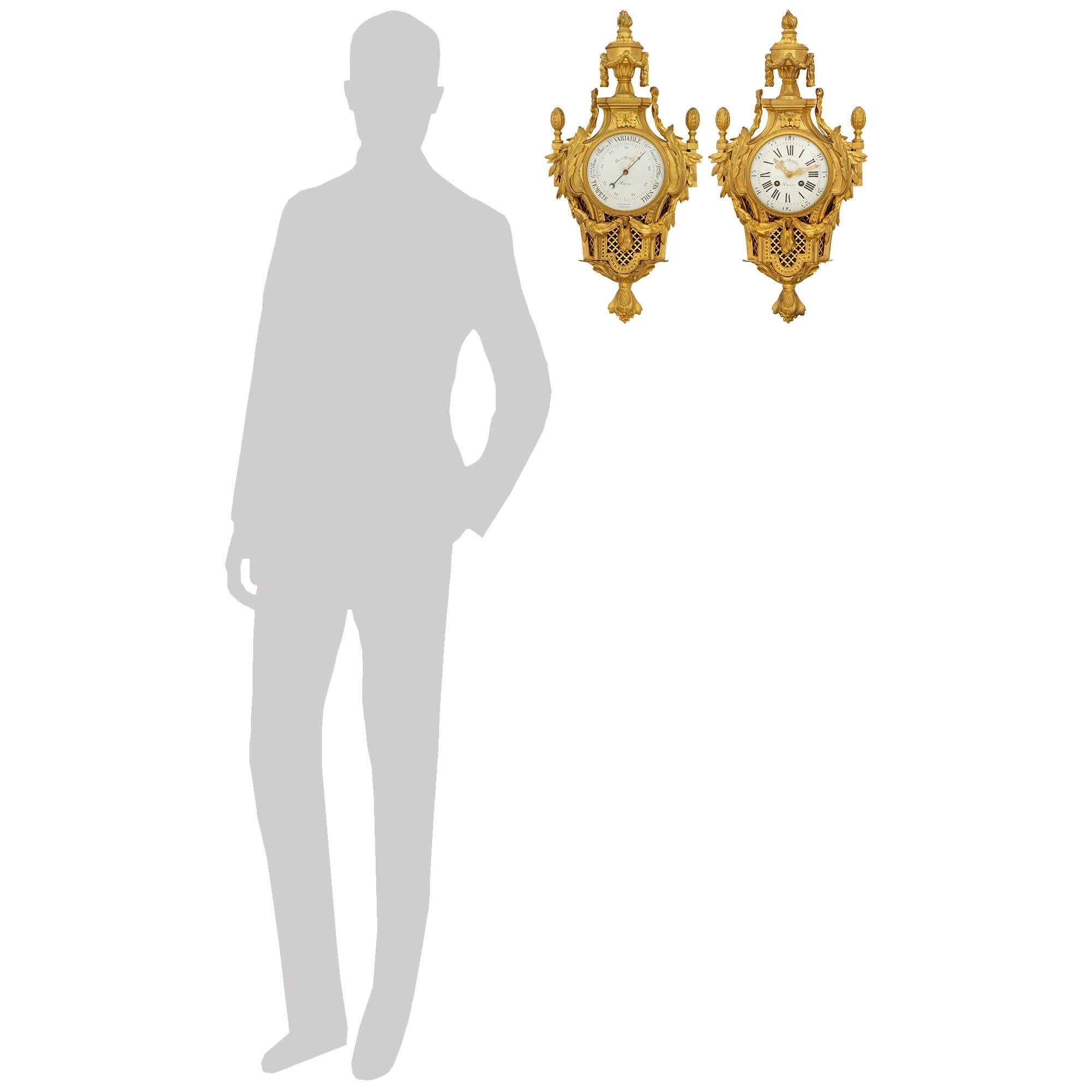 A handsome and most decorative pair of French 19th century Louis XVI st. Ormolu clock and barometer, signed by William Colin, Paris. Each stunning clock and barometer are set within matching Ormolu bodies centered at the bottom by berried finials