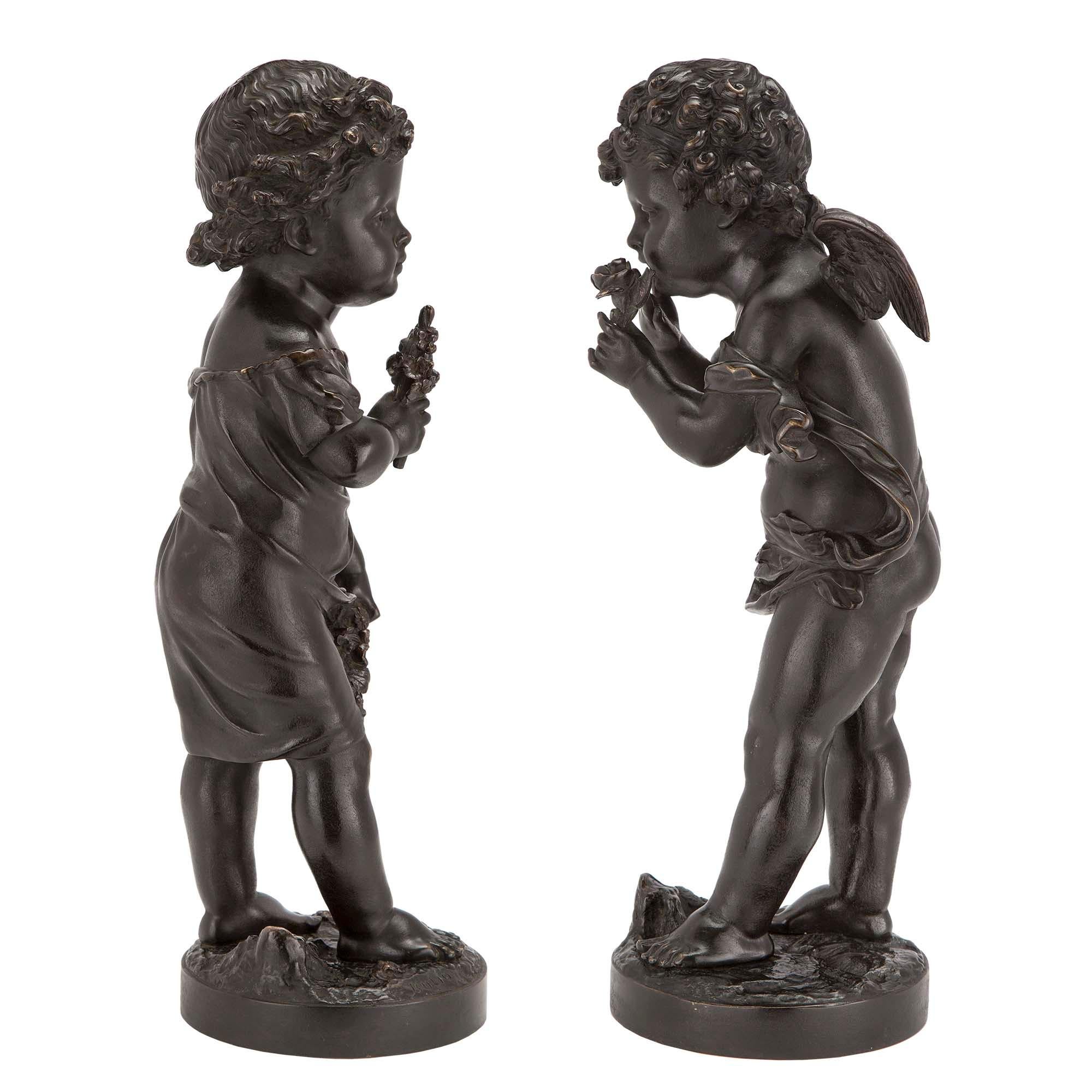 A wonderful and very decorative pair of French 19th century patinated bronzes, signed Bulio. Each is raised on a circular base depicting the ground. One bronze is of an adorable winged cupid holding a bunch of wildflowers. The other is of a precious