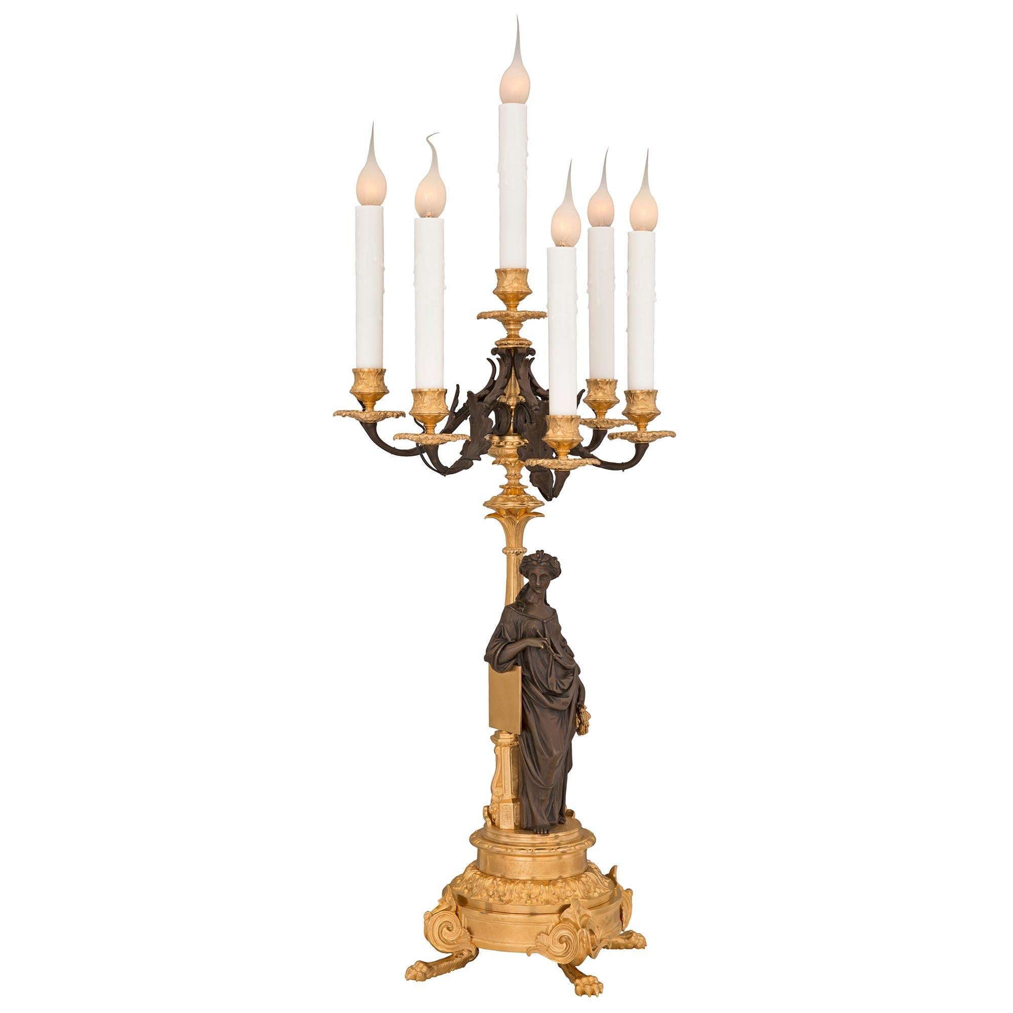 An impressive true pair of French 19th century Renaissance st. patinated bronze and ormolu candelabra lamps. Each six arm lamp is raised by handsome paw feet below scrolled foliate designs and a circular base with a wrap around acanthus leaf band.