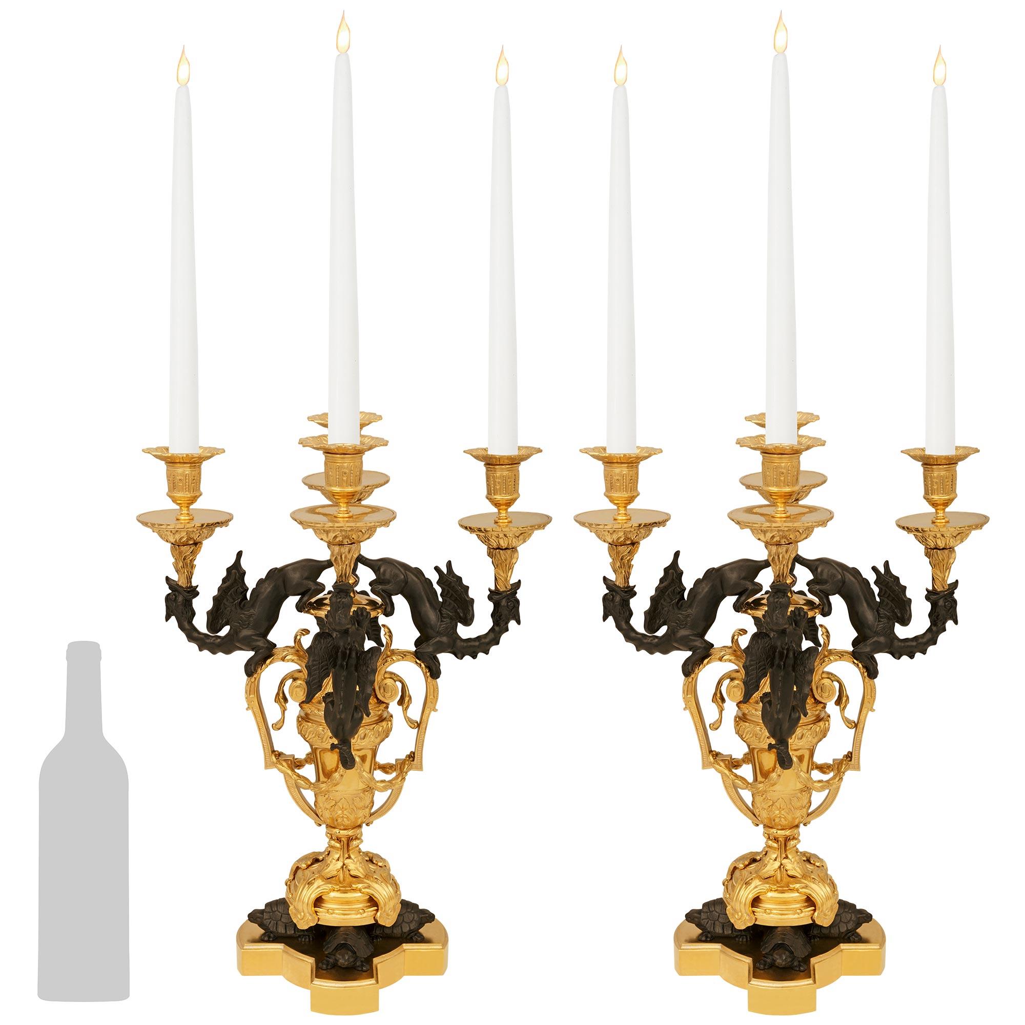 Una coppia unica e molto decorativa di candelabri francesi del XIX secolo in bronzo patinato e Ormolu. Ciascun candelabro a quattro bracci è sollevato su una base a X in Ormolu, al di sotto di tre bellissime tartarughe in bronzo patinato e