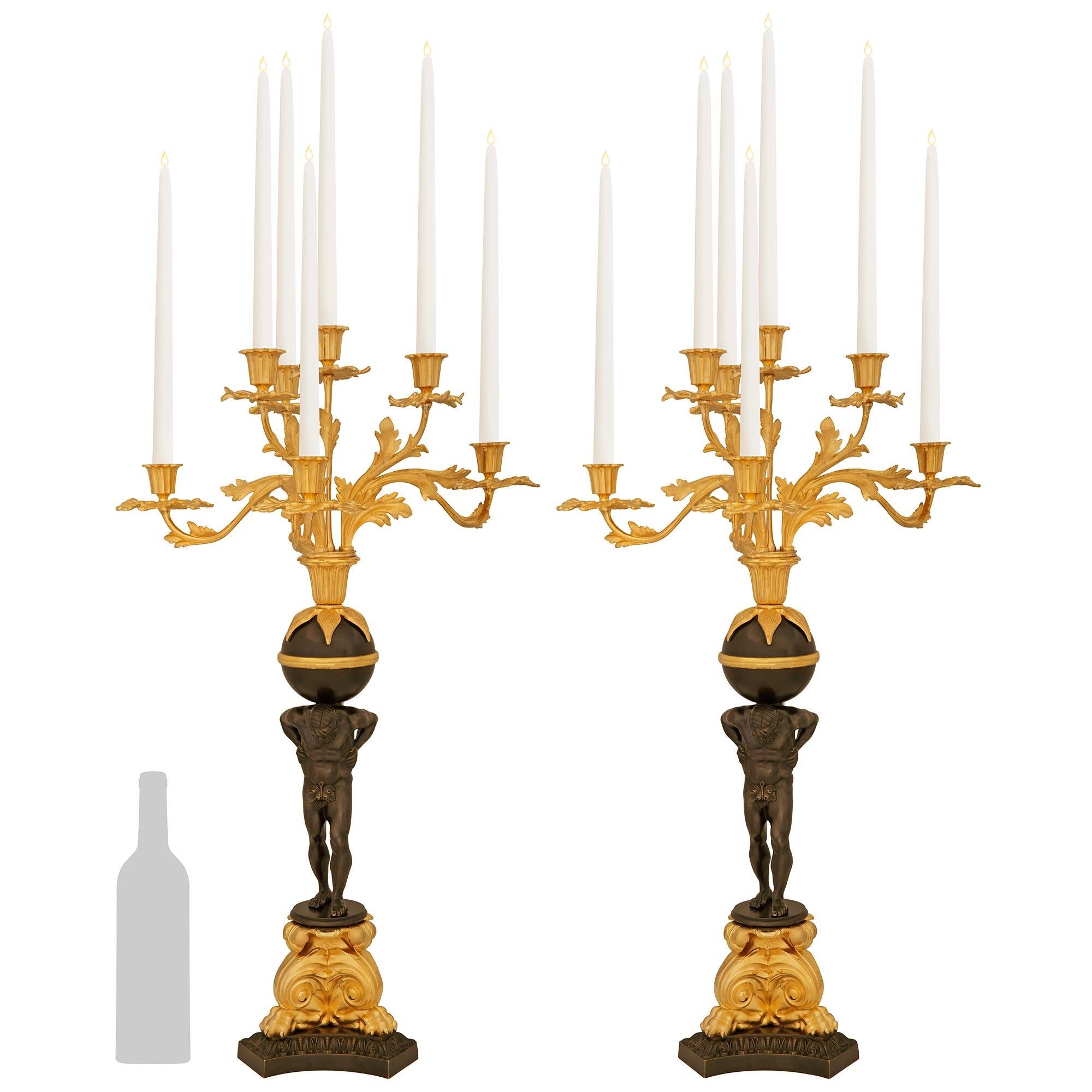 Bonita pareja de candelabros franceses del siglo XIX de bronce patinado y ormolu, de estilo renacentista. Cada candelabro de siete brazos se eleva sobre una base de Bronce patinado de forma triangular con lados cóncavos y una banda superior diseñada