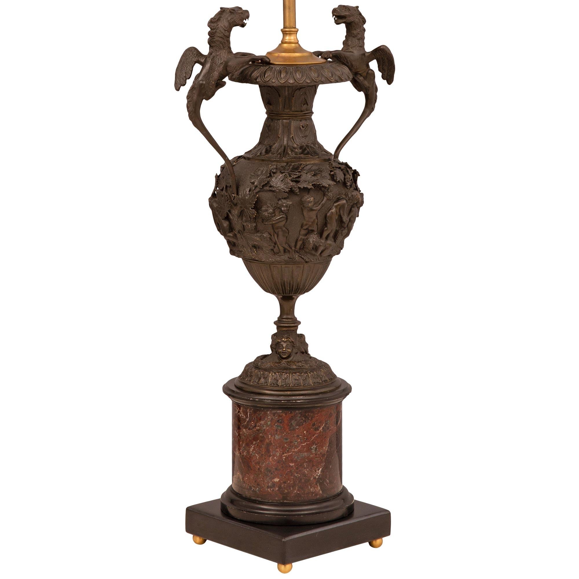 A remarkable pair of French 19th century Renaissance st. patinated bronze, Rosso Levanto, and black Belgian marble lamps. Each lamp is raised by a black Belgium marble base with fine ormolu ball feet below the beautiful circular Rosso Levanto