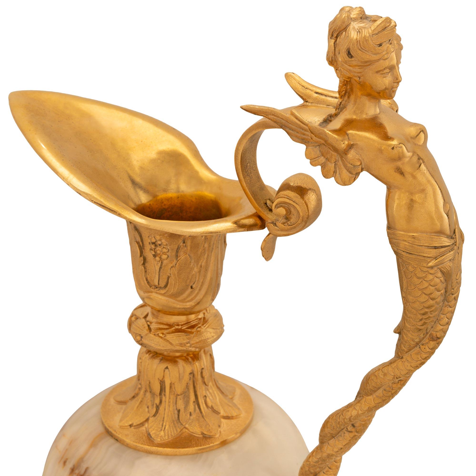 Une élégante paire d'urnes/de tours de la Renaissance française du XIXe siècle en onyx et en bronze doré. La paire est posée sur des socles carrés en onyx, sous des bases circulaires en bronze doré, avec des bordures cannelées et des palmettes