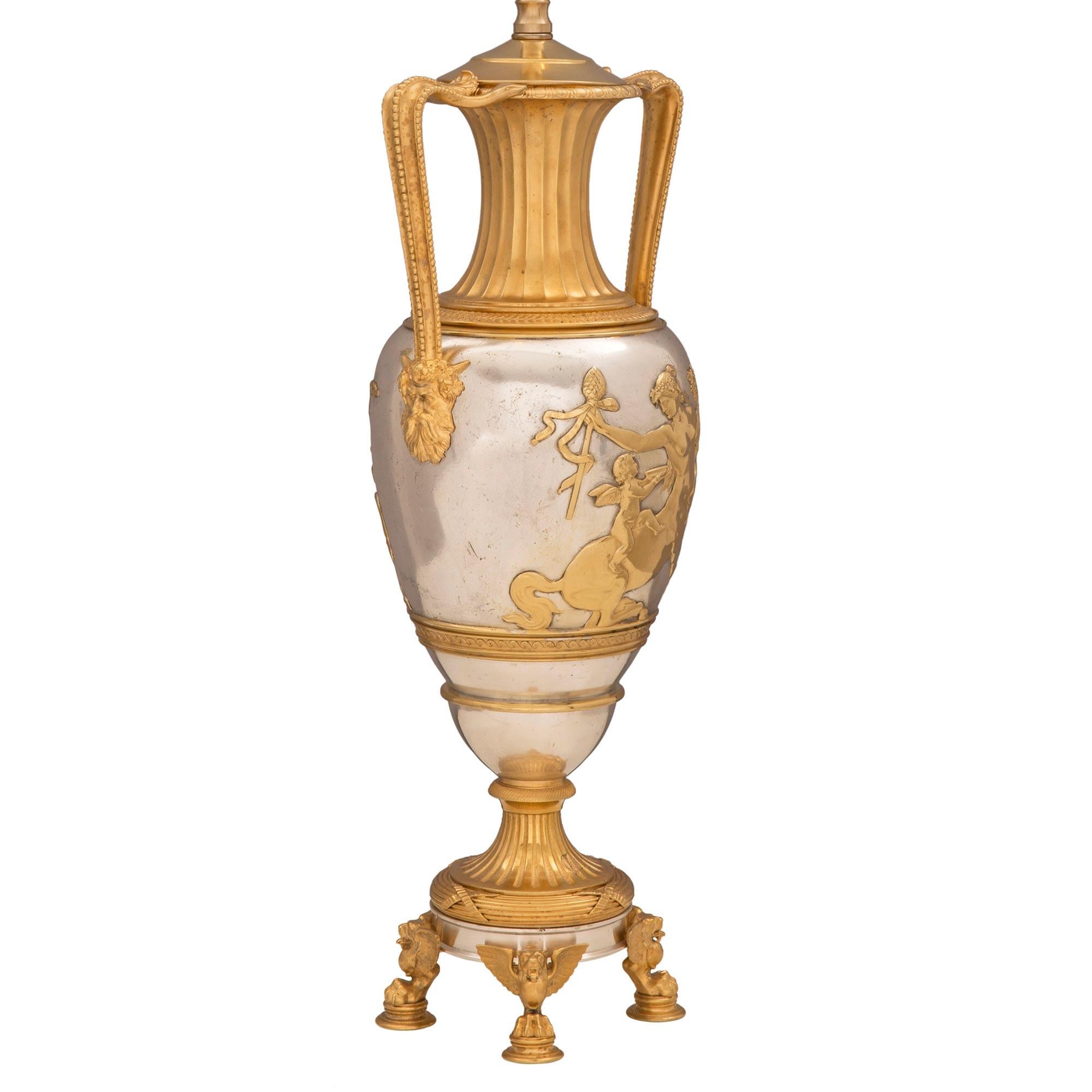Une paire élégante et extrêmement décorative de lampes françaises du 19ème siècle de style Renaissance en bronze doré et argenté. Chaque lampe est surélevée par quatre pieds circulaires finement tachetés sous de beaux pieds pattes et des têtes de