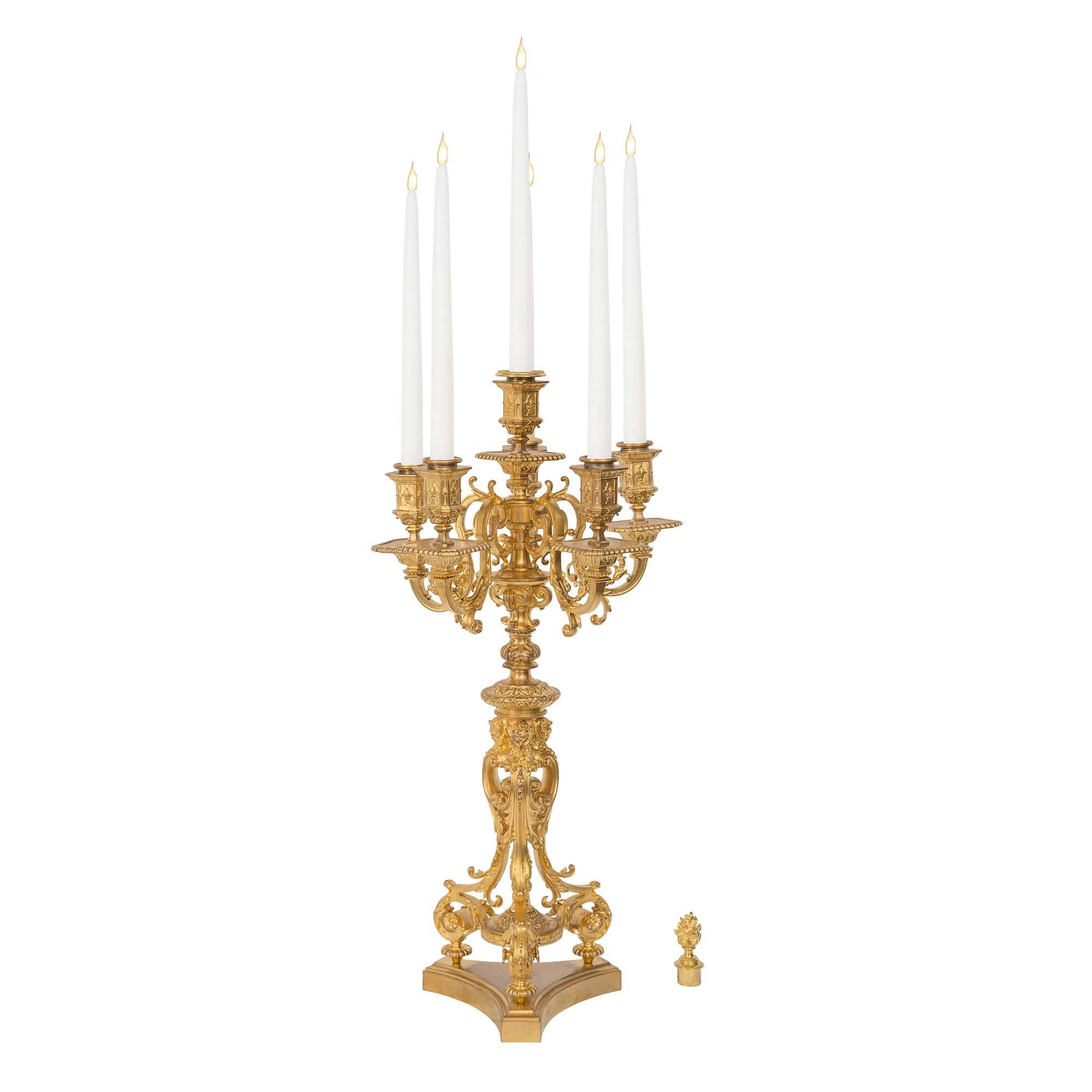 Une paire de candélabres à six bras de lumière en bronze doré de la Renaissance du 19ème siècle signée F. Barbedienne. Chaque candélabre est surélevé par une base triangulaire aux côtés concaves et au bord mouluré. Au-dessus, trois pieds en forme de