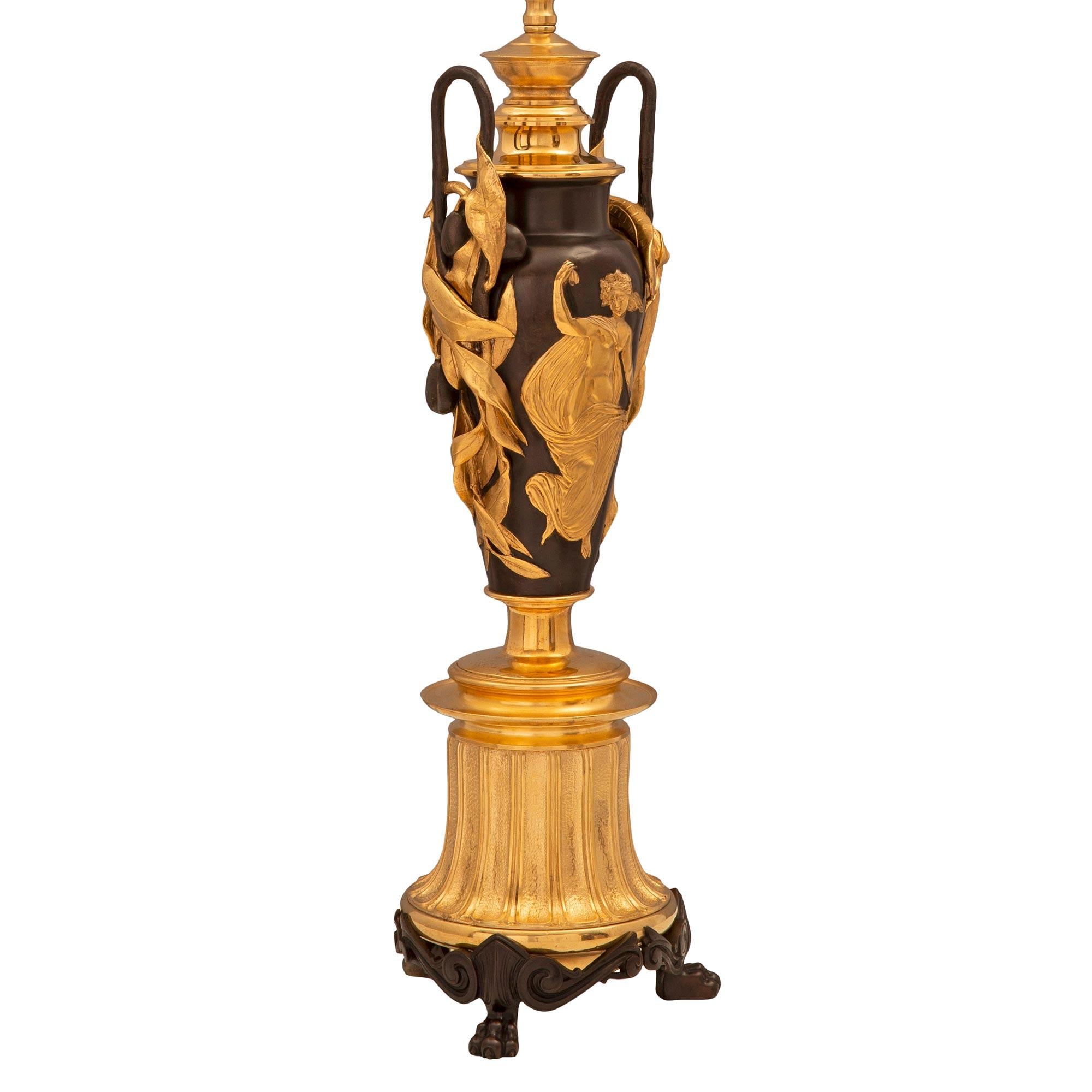 Une remarquable paire de lampes françaises du 19ème siècle de style Renaissance en bronze patiné et bronze doré. Chaque lampe est surélevée par trois beaux pieds en bronze patiné avec des motifs feuillus en volutes, sous une base cannelée légèrement
