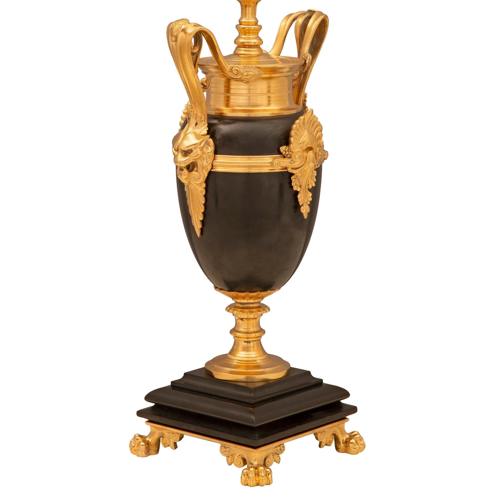 Paire d'étonnantes lampes françaises du XIXe siècle, de style Renaissance, en bronze patiné et bronze doré. Chaque lampe est surélevée par une élégante base étagée et tachetée avec de beaux pieds en patte et un support de piédestal en forme de