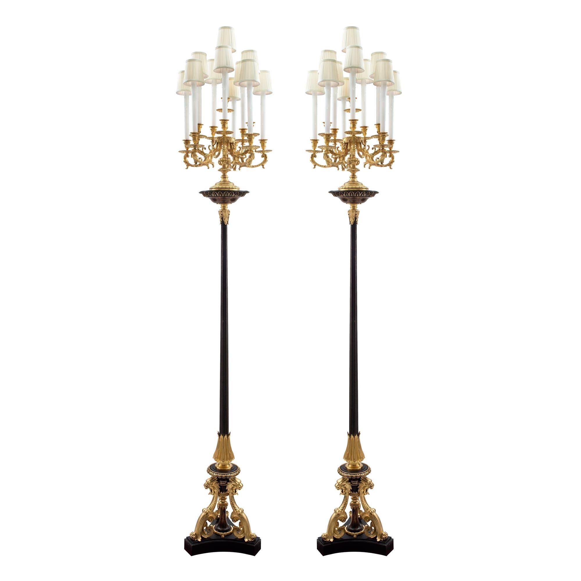 Ein aufsehenerregendes und großformatiges Paar französischer Stehlampen / Torchières aus Ormolu und patinierter Bronze aus der Renaissance des 19. Jahrhunderts, die Henri Picard zugeschrieben werden. Jede Stehlampe wird von einem feinen dreieckigen