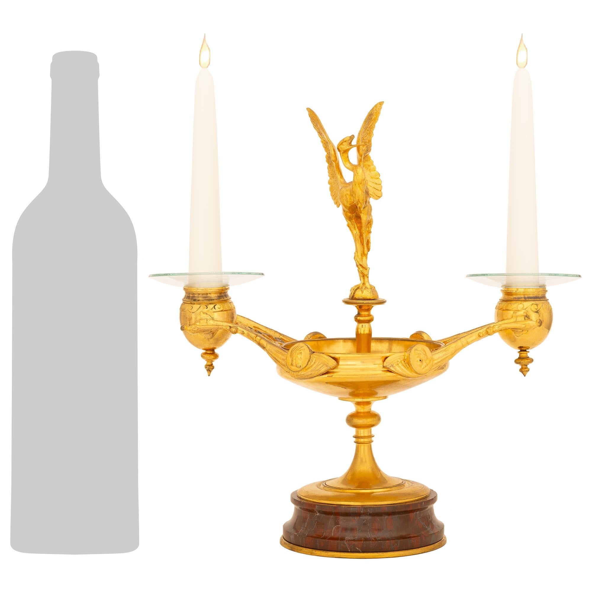 Una splendida coppia di candelabri rinascimentali francesi del XIX secolo in Ormolu e marmo Rouge Griotte. Ogni elegantissimo candelabro a due bracci è sollevato da una base circolare in marmo Rouge Griotte sopra una delicata piastra di base in