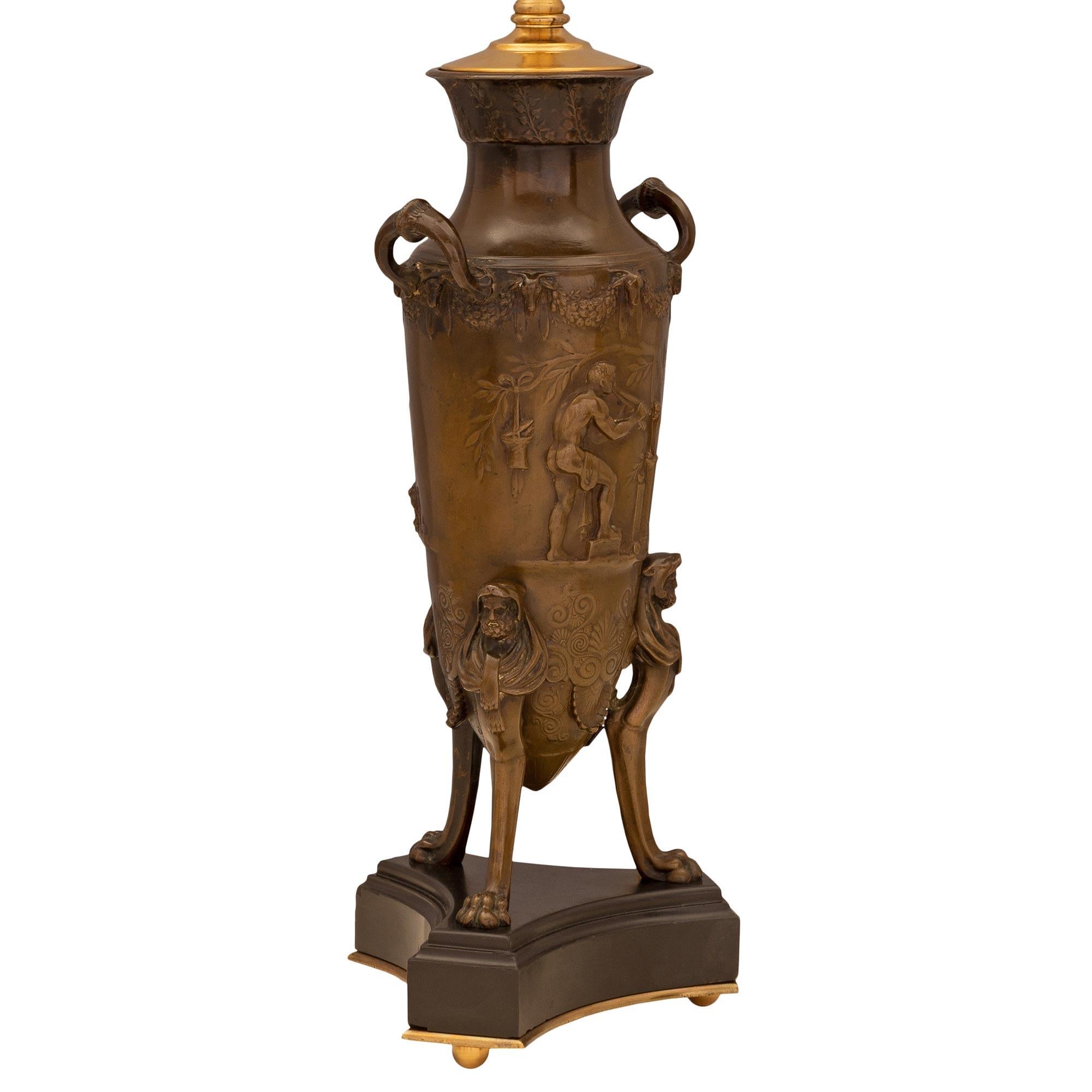 Une belle paire de lampes en bronze patiné et en marbre de style Renaissance française du 19ème siècle. Chaque lampe est surélevée par des pieds à boule en bronze doré sous la base triangulaire en marbre noir de Belgique, avec des angles coupés et