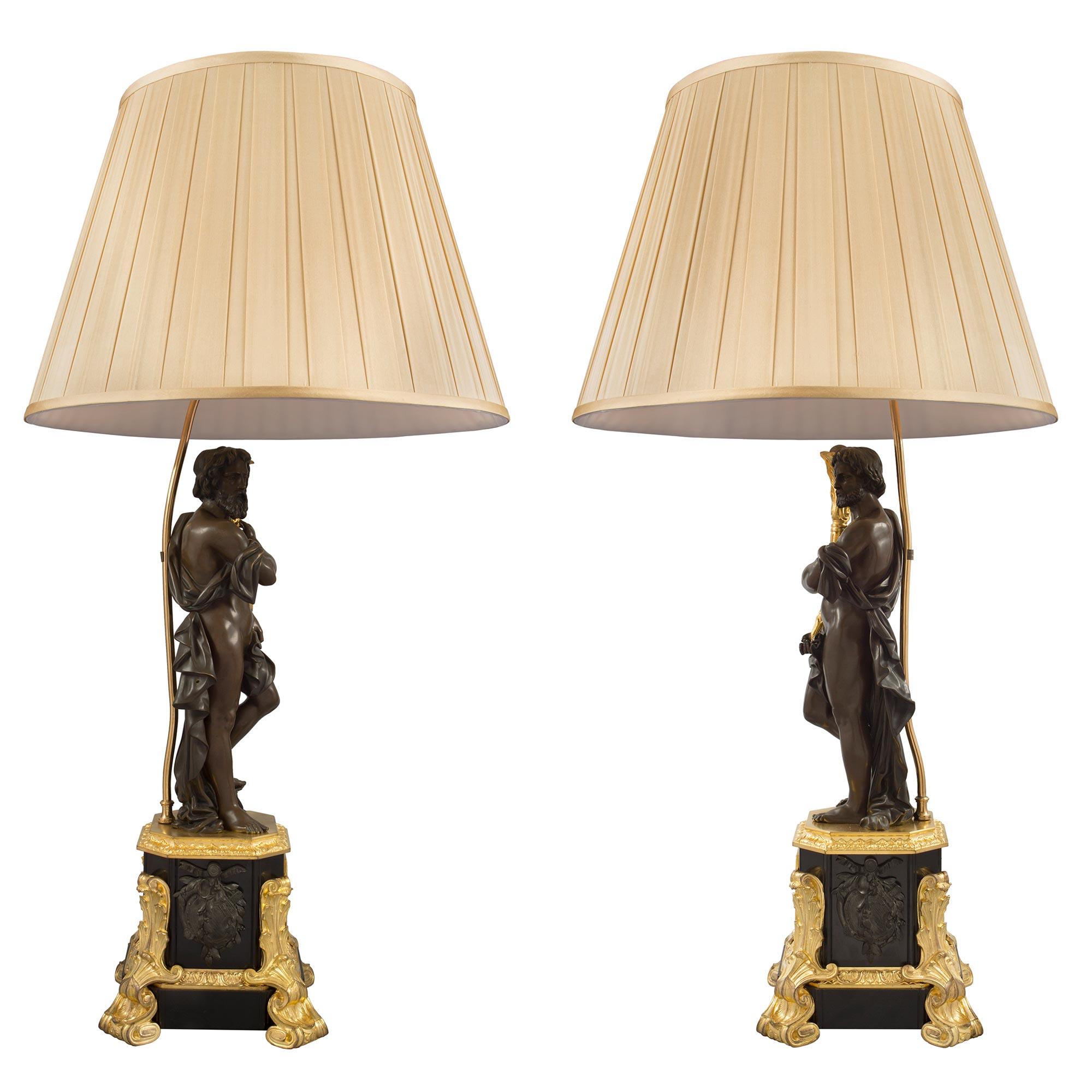 Un'impressionante coppia di lampade francesi del XIX secolo in stile rinascimentale in bronzo patinato e ormolu. Ogni lampada è sollevata da suggestivi piedini in ormolu a forma di voluta e di fogliame che risalgono i lati della base quadrata. Nella