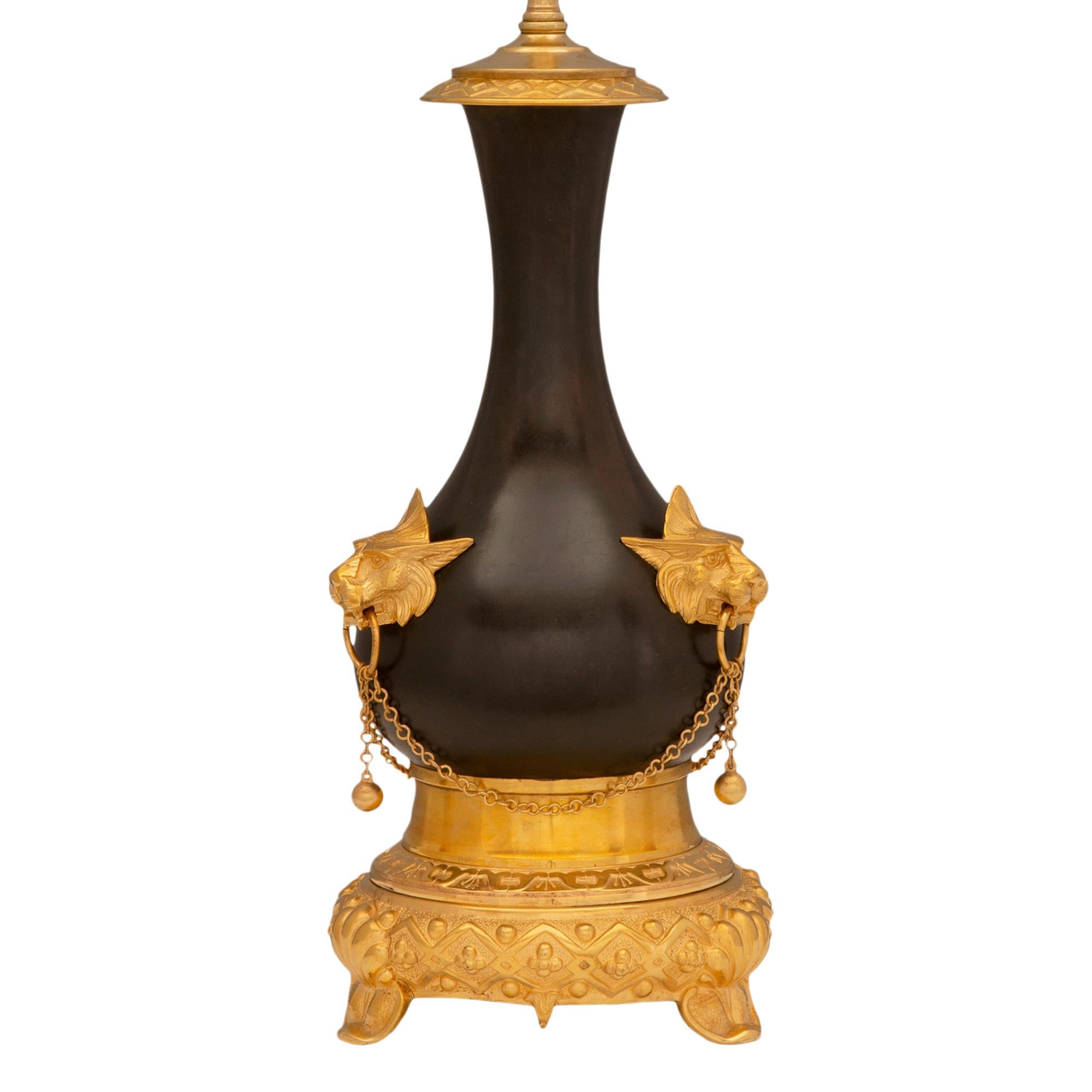 Une remarquable paire de lampes françaises du 19ème siècle de style Renaissance en bronze patiné et bronze doré. Chaque lampe est surélevée par une élégante base circulaire avec trois supports en forme de coquillage et un magnifique et unique